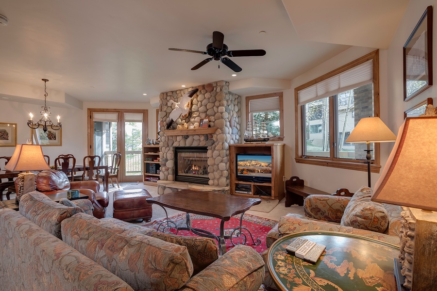 Sink into plush seating by the stone fireplace, where warm lighting and mountain-home charm create your perfect retreat after a day of adventure.