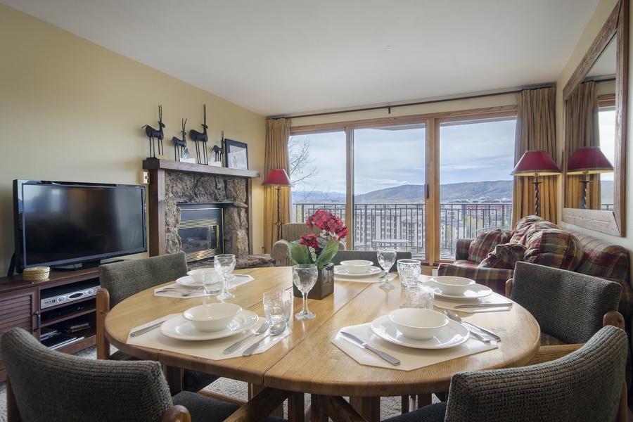 Relax in this welcoming living and dining space with a cozy fireplace, mountain views, and everything set for memorable meals during your stay.