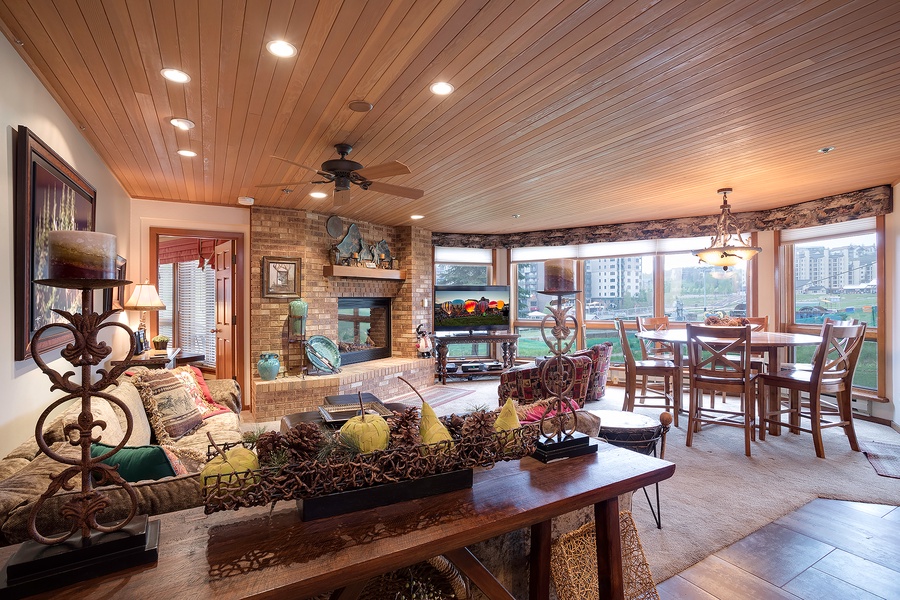 Unwind in this spacious, light-filled living area where warm wood ceilings and a cozy fireplace create the perfect retreat after your day of adventure.