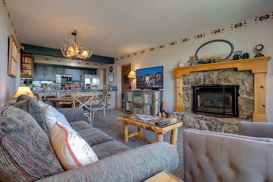Cozy mountain retreat with rustic stone fireplace, open-concept living and dining, and a fully equipped kitchen perfect for your alpine getaway.
