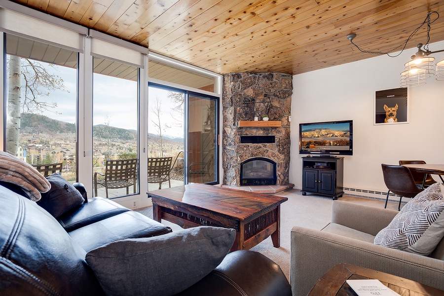 Sink into plush seating and gaze at mountain vistas through floor-to-ceiling windows. The stone fireplace adds warmth while you unwind after a day exploring nearby slopes.
