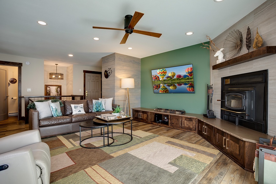 You'll love unwinding in this stylish living room with its cozy fireplace, comfortable leather seating, and modern entertainment setup—perfect for relaxing after your adventures.