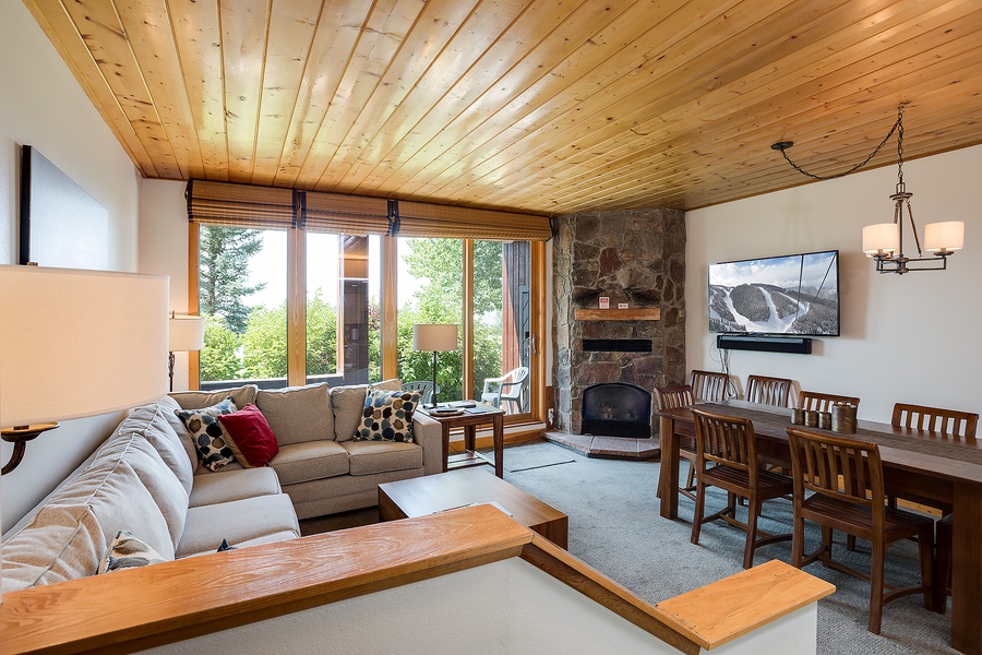 Unwind in your cozy mountain retreat with a crackling fireplace, plush seating, and natural wood accents that create a warm, inviting atmosphere for your alpine getaway.