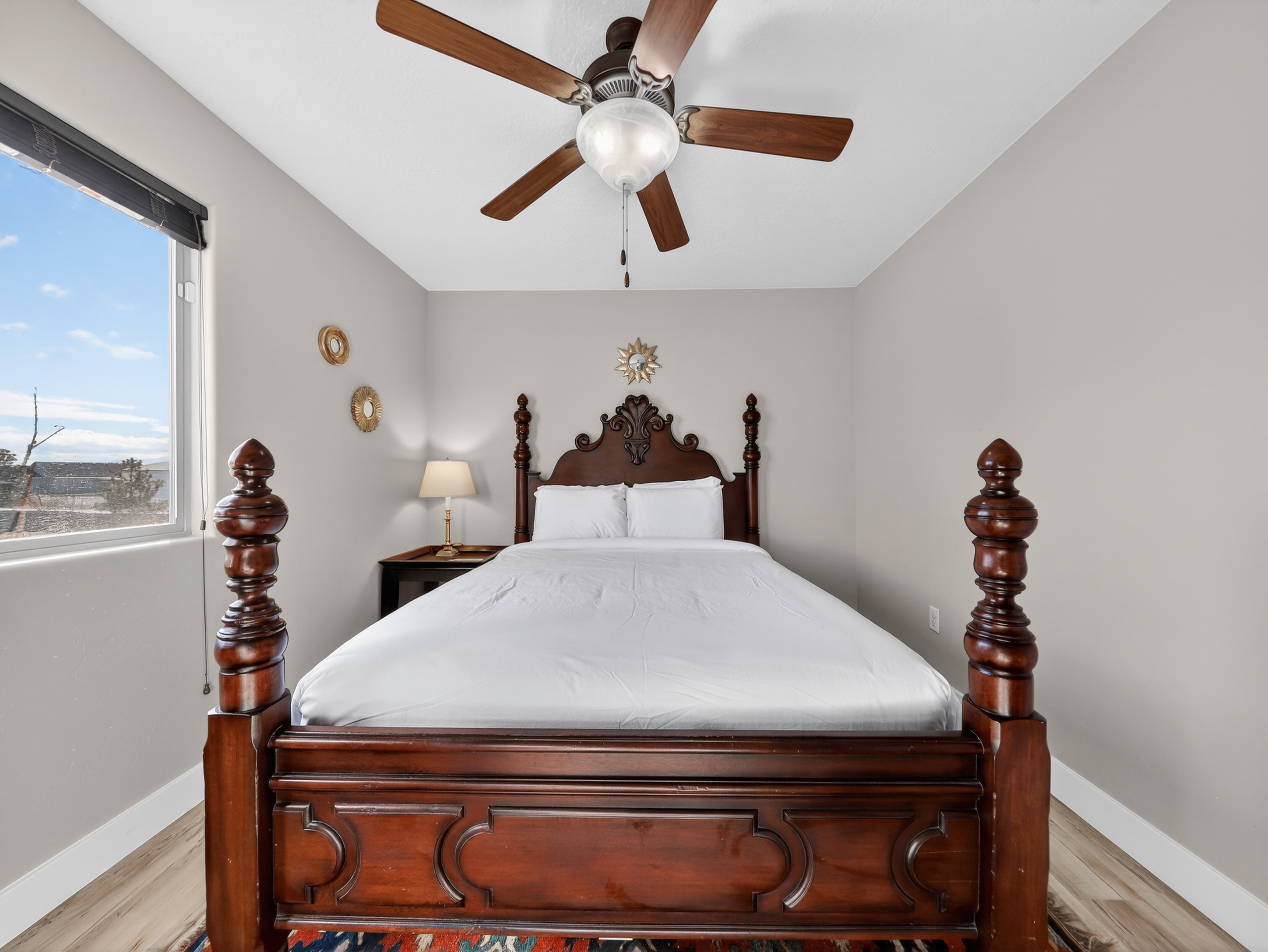 Drift off in this elegant bedroom with its stately four-poster bed, crisp linens, and gentle ceiling fan breeze.