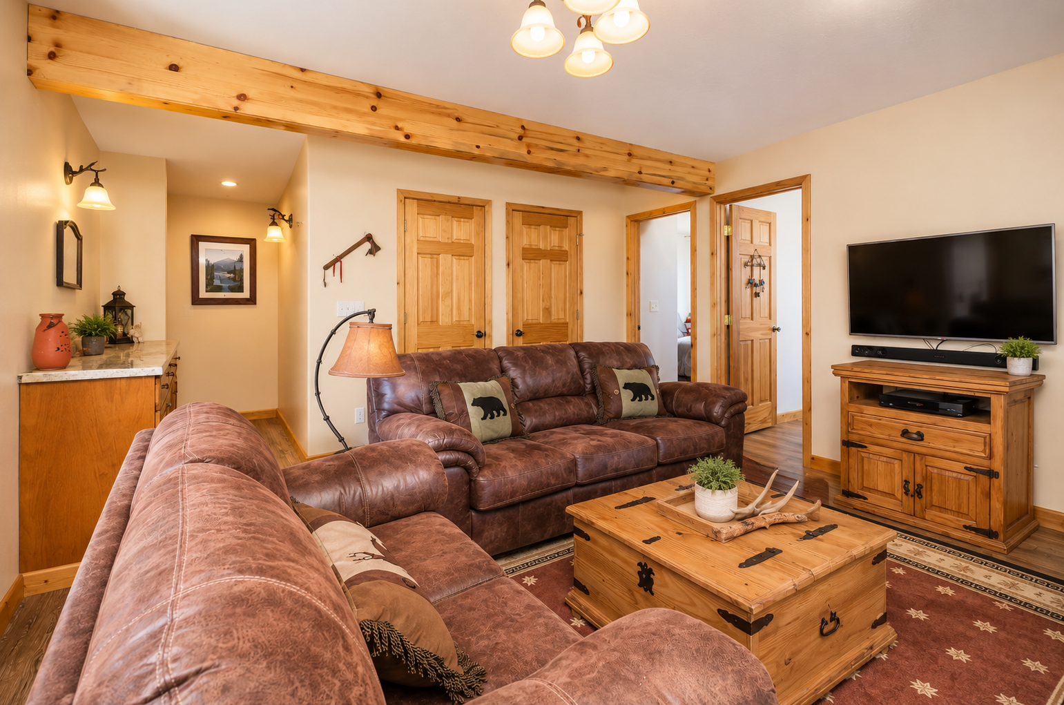 Sink into plush leather sofas under rustic wood beams, where warm lighting and cozy cabin accents invite you to unwind with your favorite shows after a day of adventure.