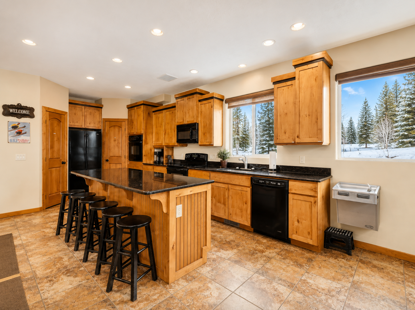 Gather around the spacious island in your fully-equipped kitchen, where warm wood tones and modern appliances set the stage for memorable meals together.