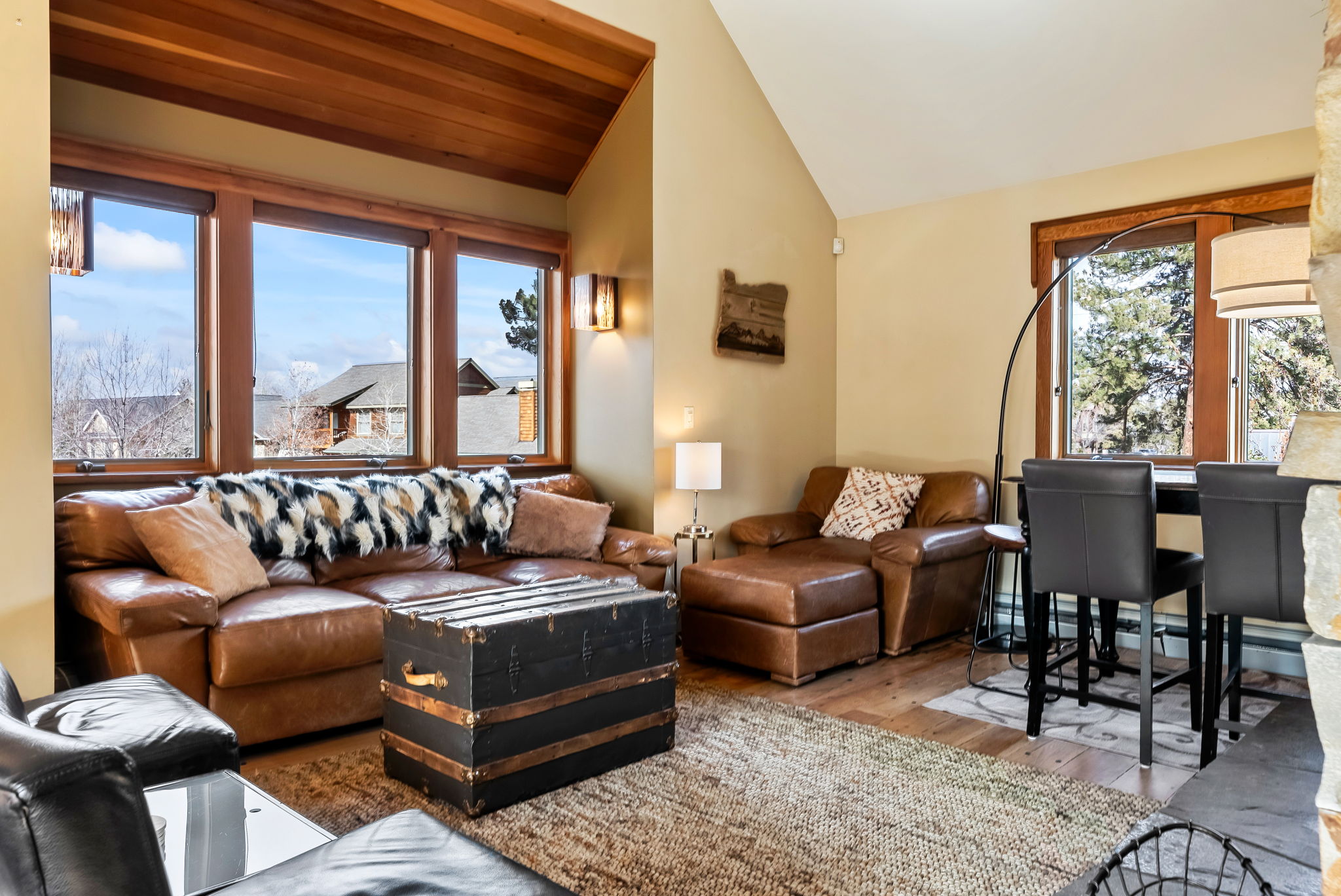 Unwind on plush leather seating in your bright, vaulted living space, where warm wood beams and mountain views invite relaxation and cozy conversation.