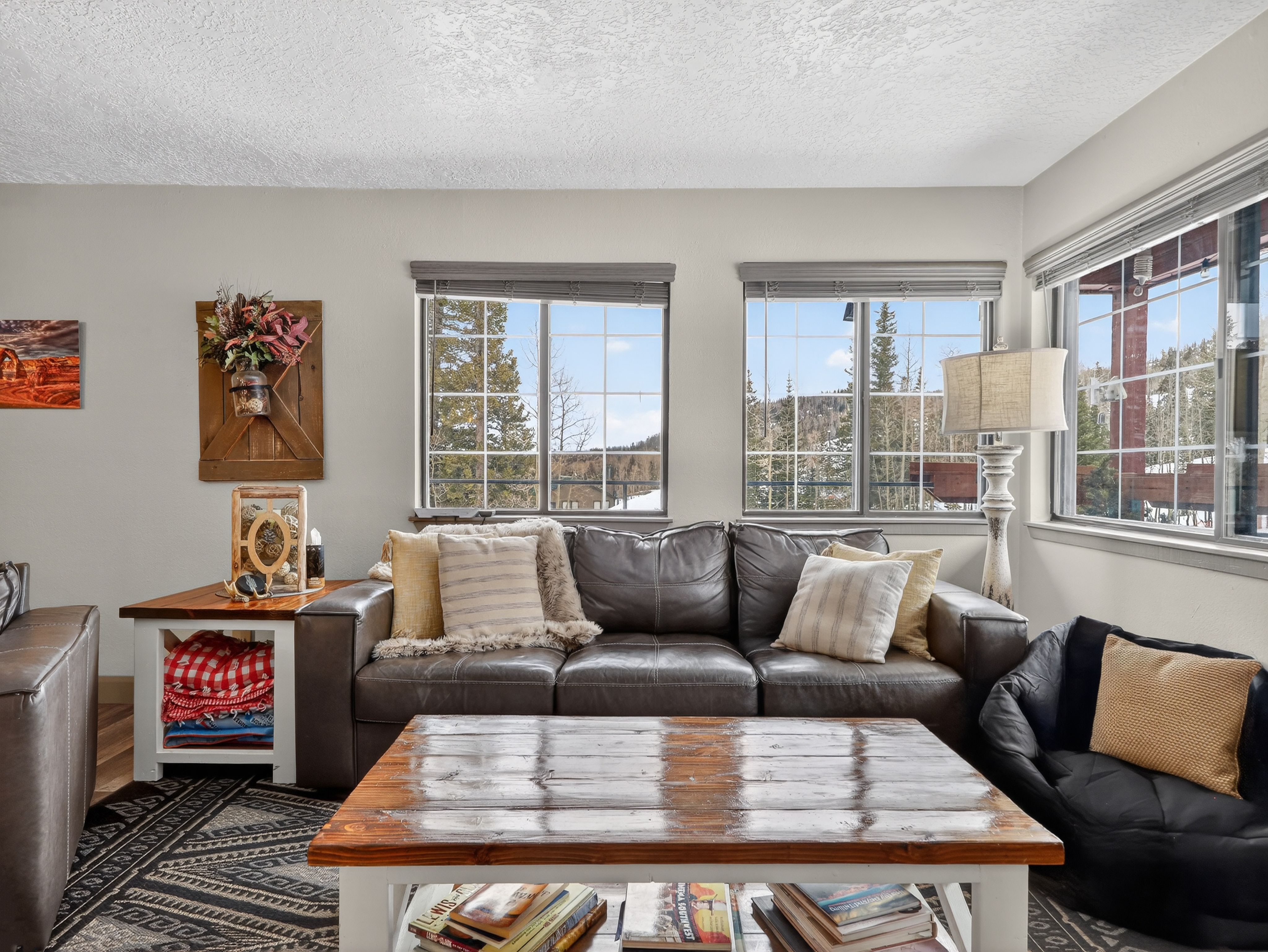 Sink into the plush leather sectional and watch snow-dusted mountains frame your cozy retreat through expansive windows.
