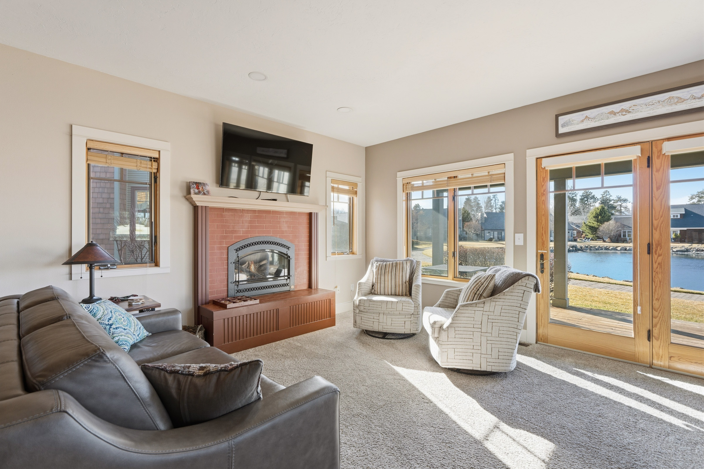 Unwind in your cozy living room with a crackling fireplace and stunning lake views streaming through floor-to-ceiling windows.