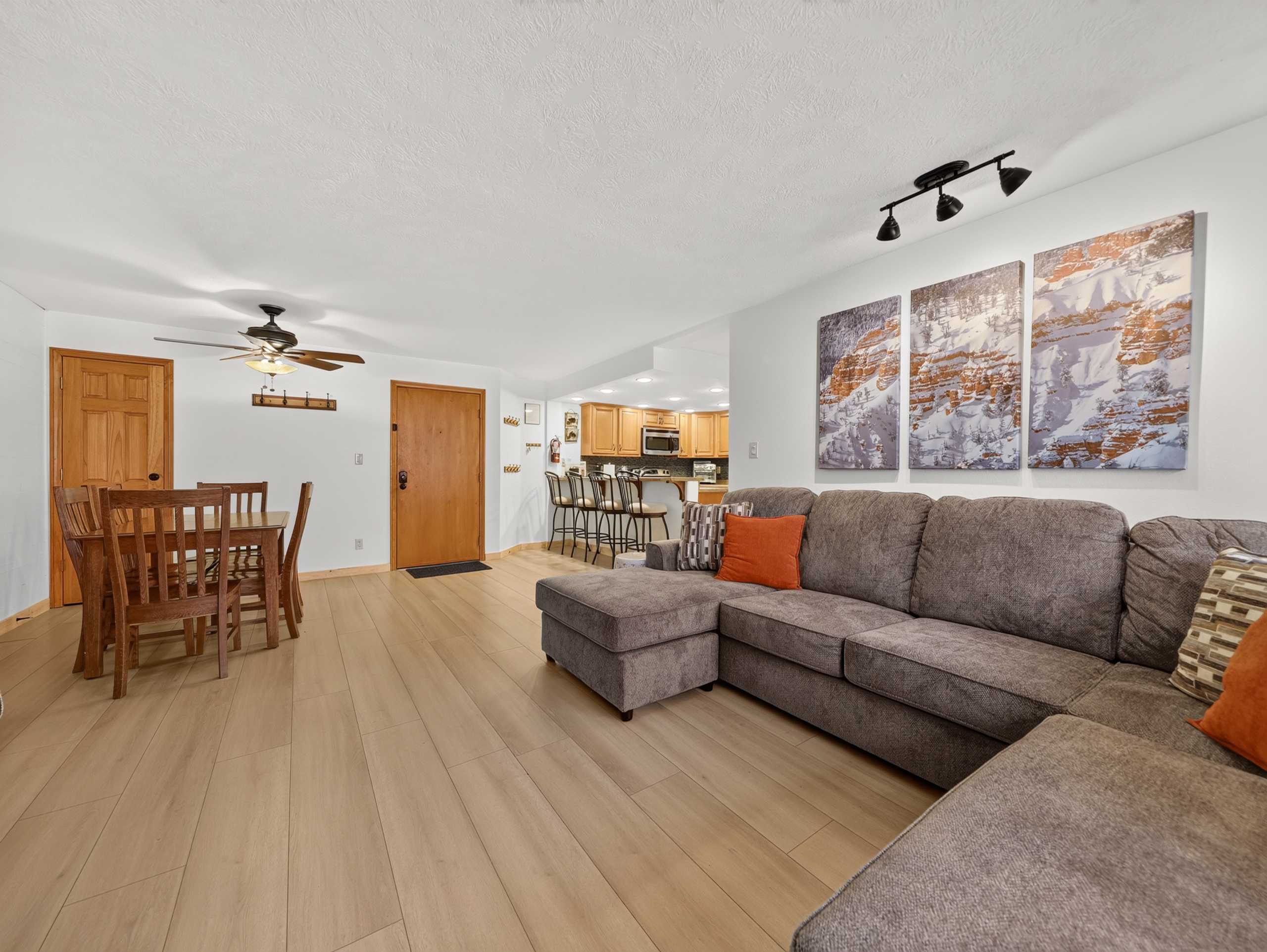 Spacious living area with plush sectional sofa and open floor plan connecting seamlessly to dining and kitchen—perfect for gathering and creating lasting vacation memories.
