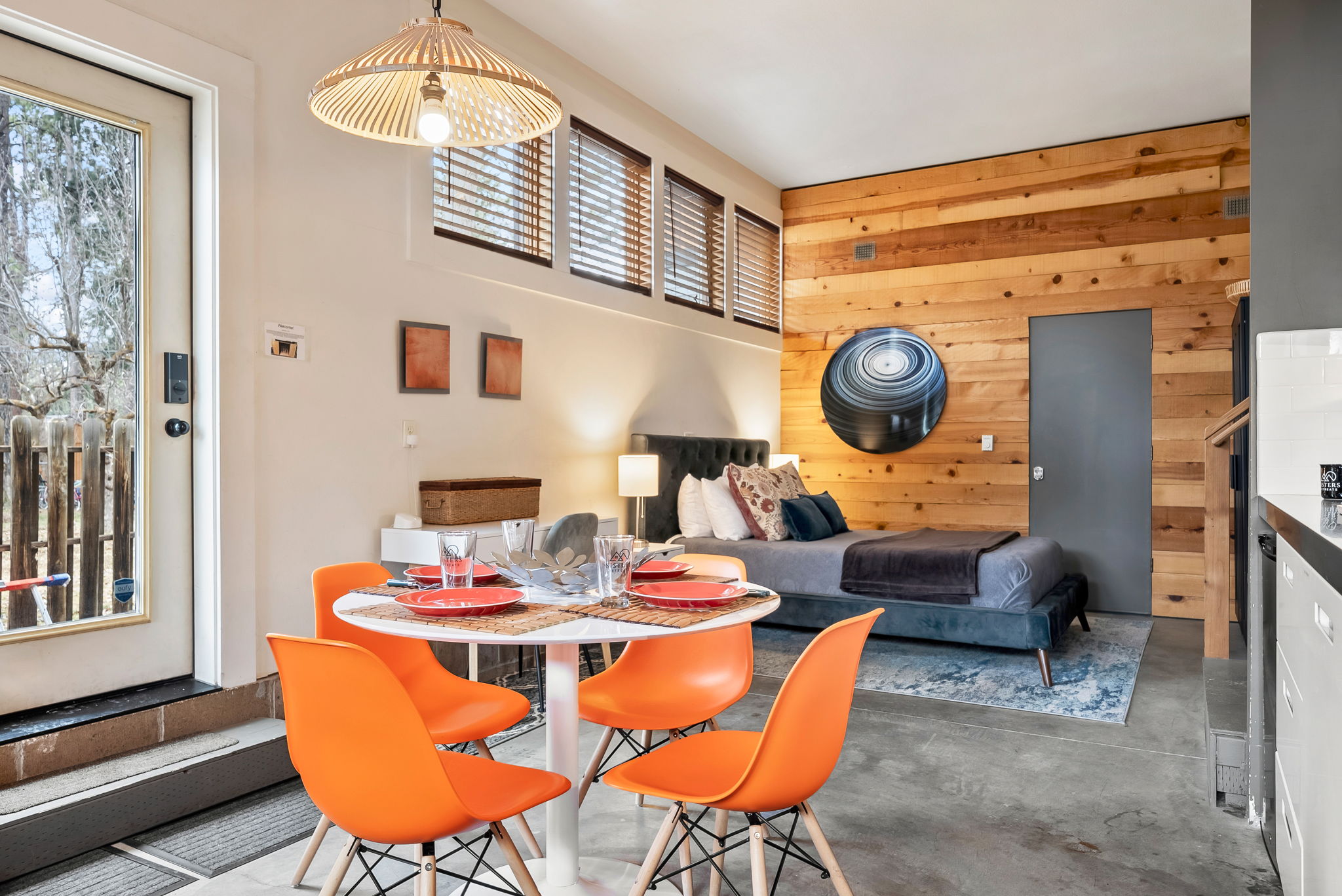 Step into your open-concept retreat where warm wood accents meet modern design. Natural light floods through high windows, illuminating your cozy living and dining spaces—perfect for relaxing evenings or memorable meals together.