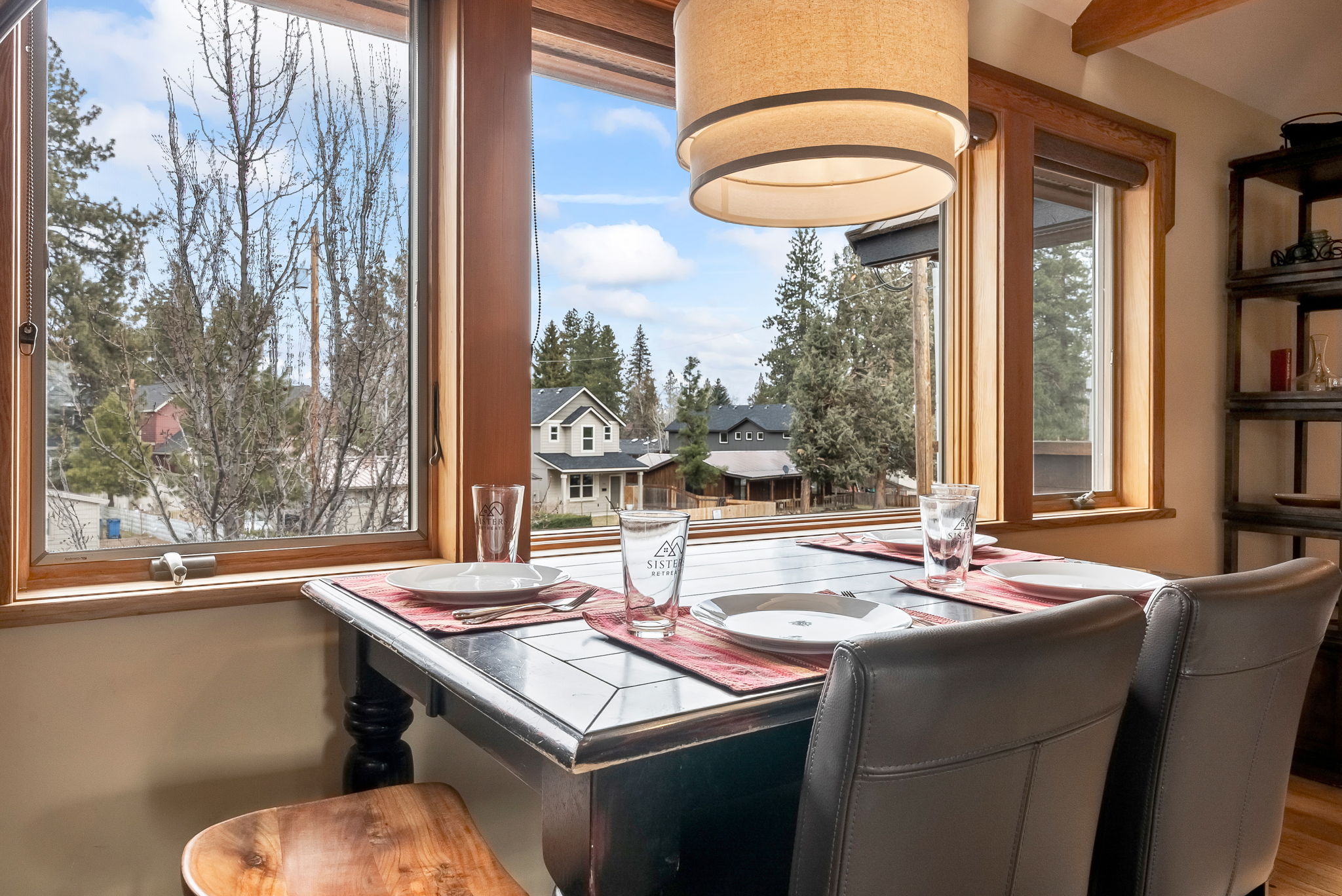 Enjoy your morning coffee at this cozy dining nook, where charming mountain-town views through expansive windows make every meal feel special.