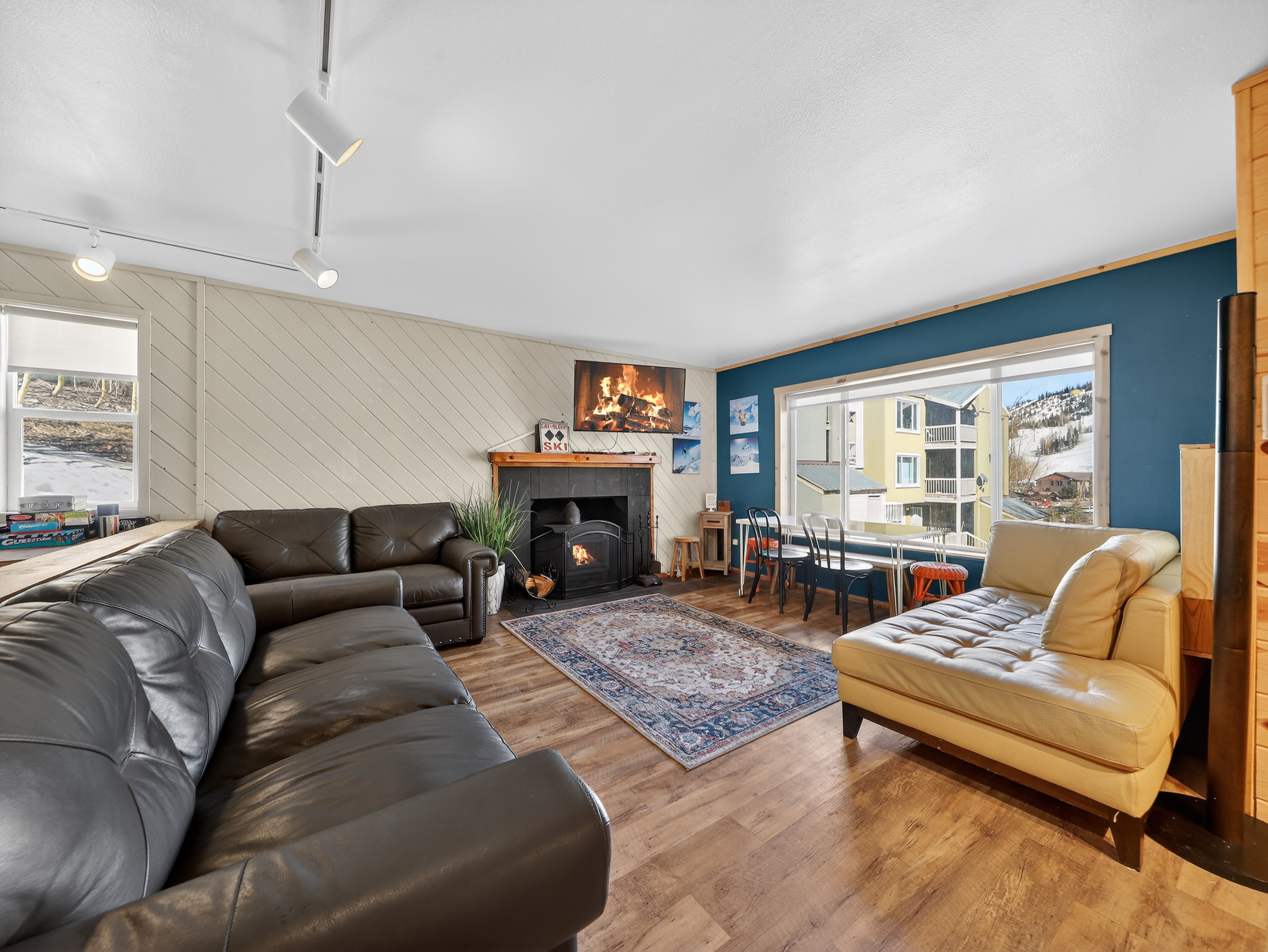Unwind in your stylish living room with plush leather seating and a cozy fireplace, perfect for relaxing after mountain adventures.