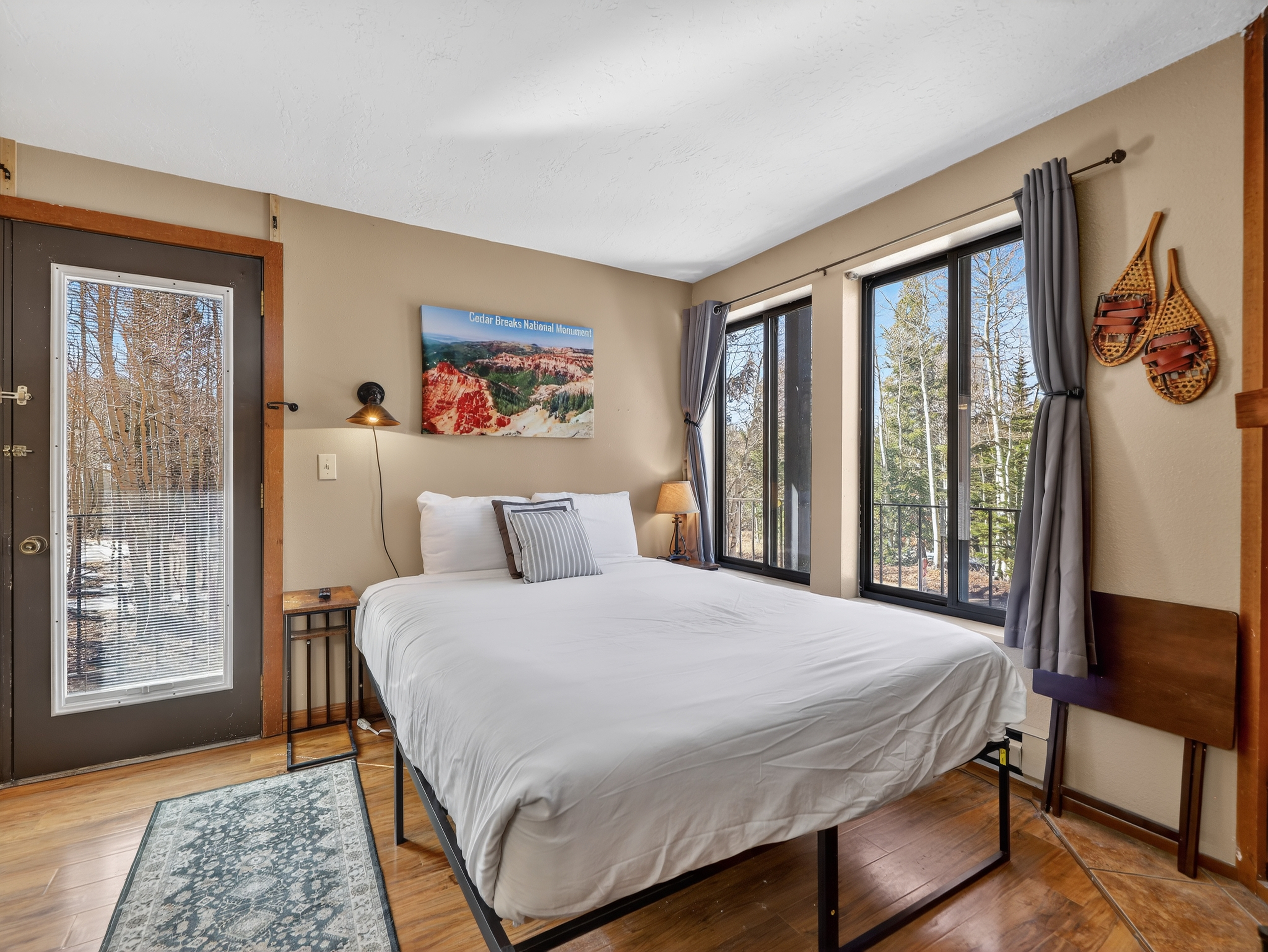 Settle into this cozy bedroom where crisp white linens and warm wood touches create your perfect mountain retreat sanctuary.