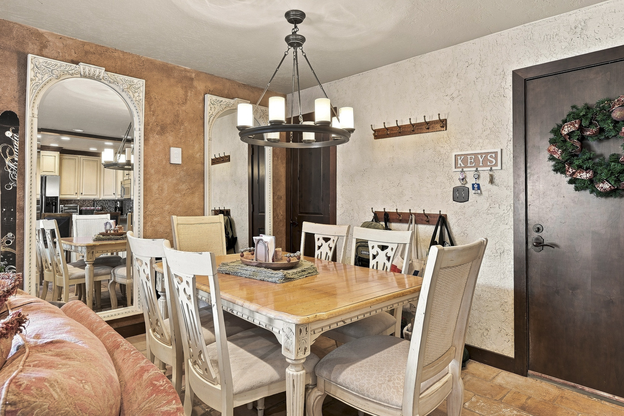 Gather around this inviting farmhouse-style dining table under a rustic chandelier. The open flow to the kitchen creates a cozy, welcoming space for memorable meals with loved ones.