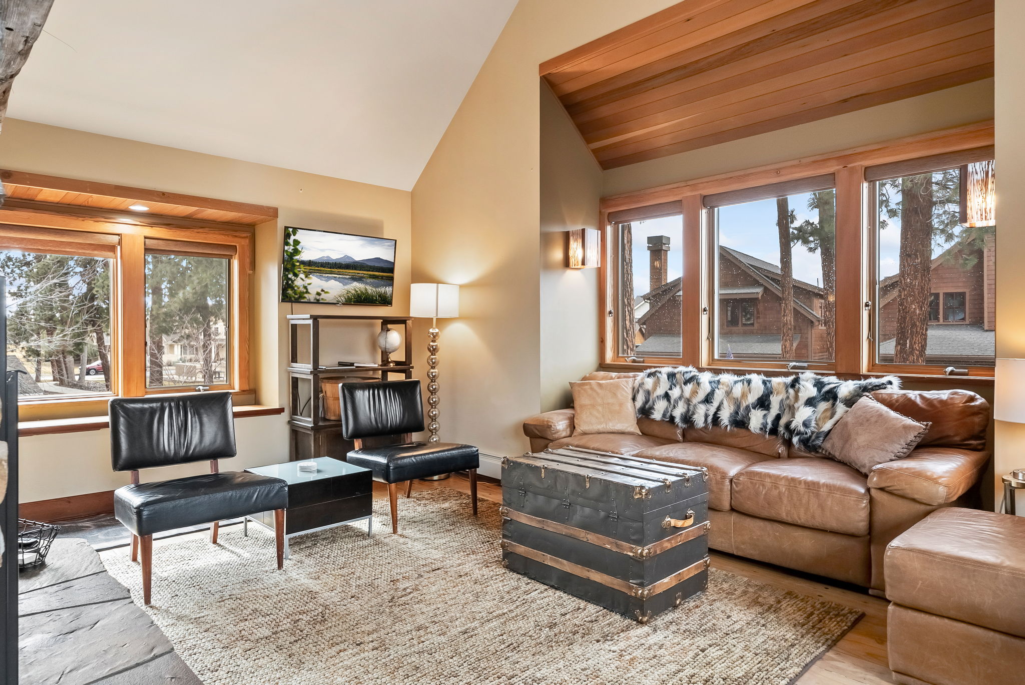 Sink into plush leather seating in your airy living room, where exposed wood beams frame alpine views and a vintage trunk doubles as your coffee table.