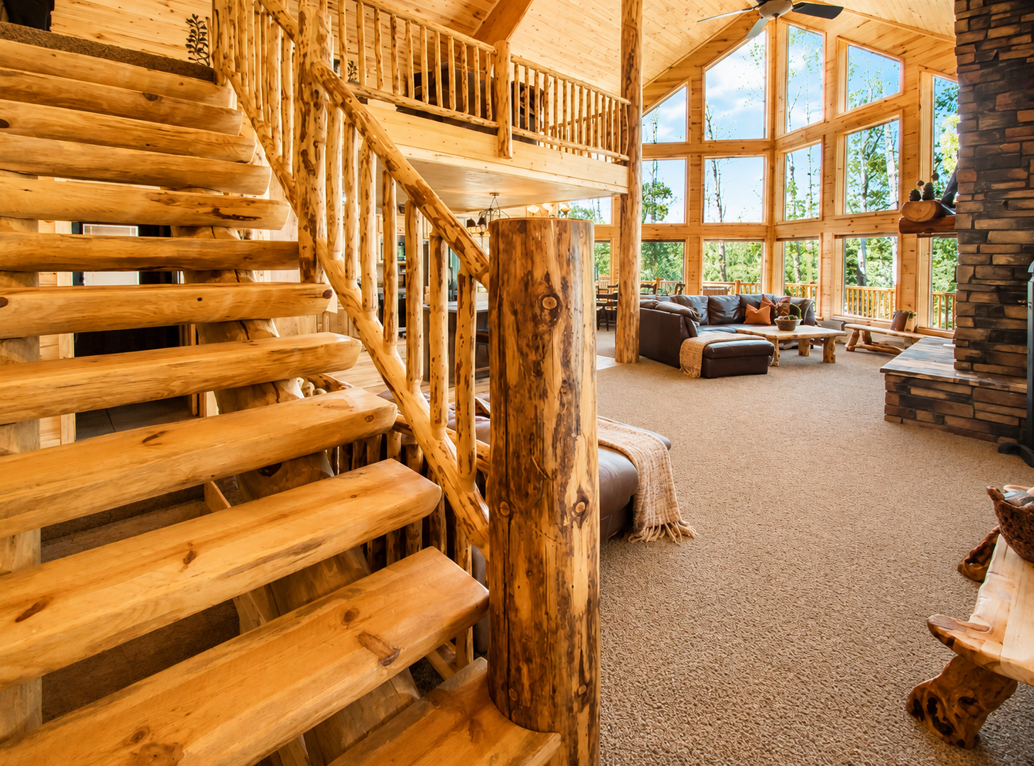 Sunlight pours through floor-to-ceiling windows into your cozy, handcrafted log cabin living room, where rustic charm meets mountain comfort. Relax by the stone fireplace and breathe in nature.