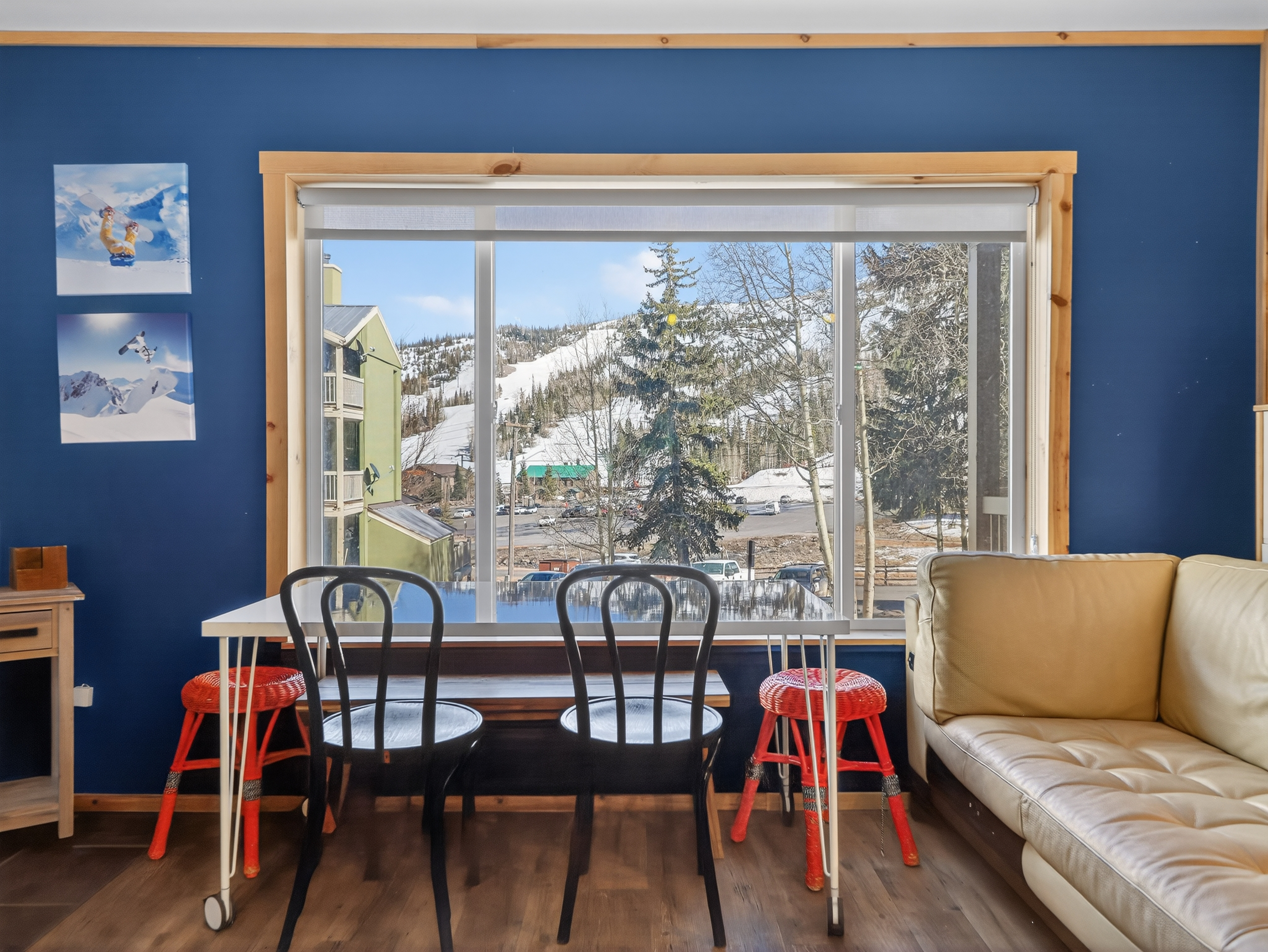 Cozy dining space with mountain views where you can enjoy meals while taking in snowy ski slopes through large picture windows.