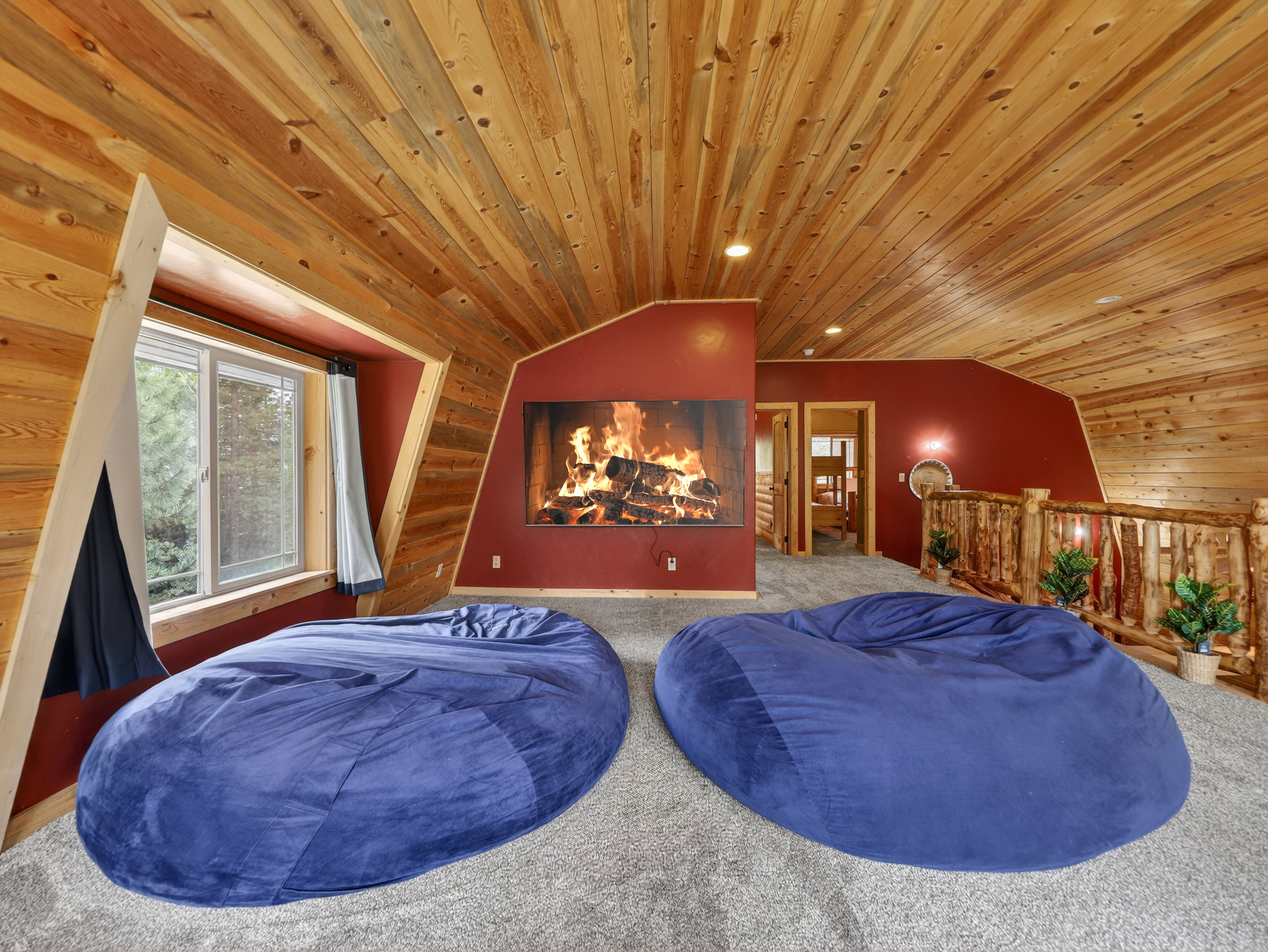 Sink into plush oversized bean bags and watch the flames dance—your cozy retreat with warm wood tones and a crackling fire awaits.