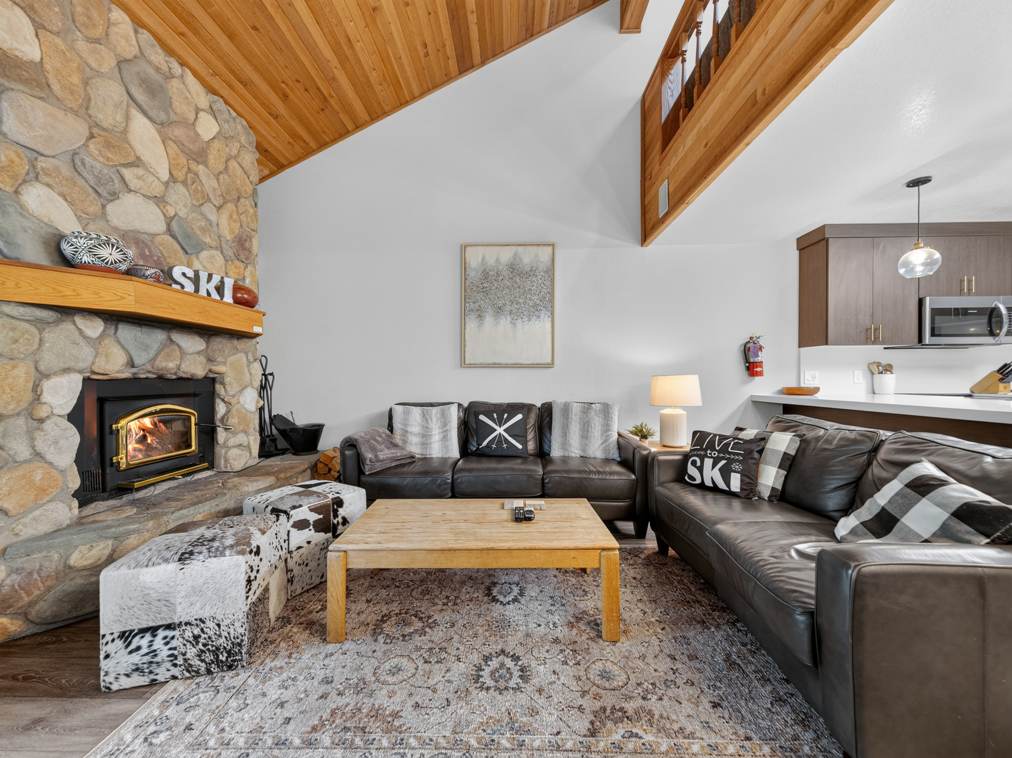 Step into your cozy mountain retreat, where exposed beams and a crackling stone fireplace invite you to unwind. Sink into the plush leather sofas and let the warmth embrace you after a day on the slopes.