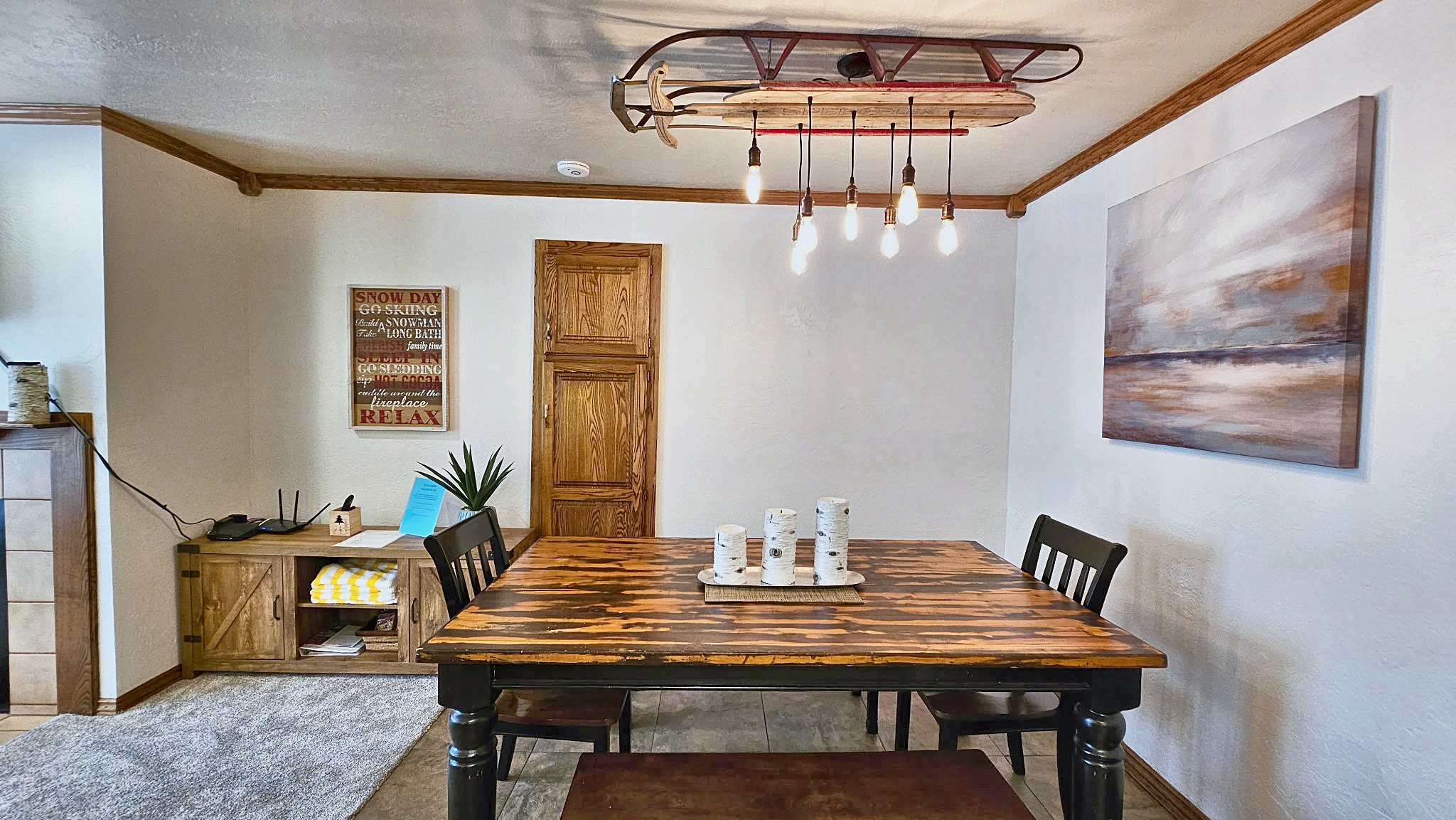 Gather around the handcrafted dining table under unique sled-inspired lighting. The warm wood tones and mountain-inspired touches create a welcoming space where your group can share meals and make memories together.