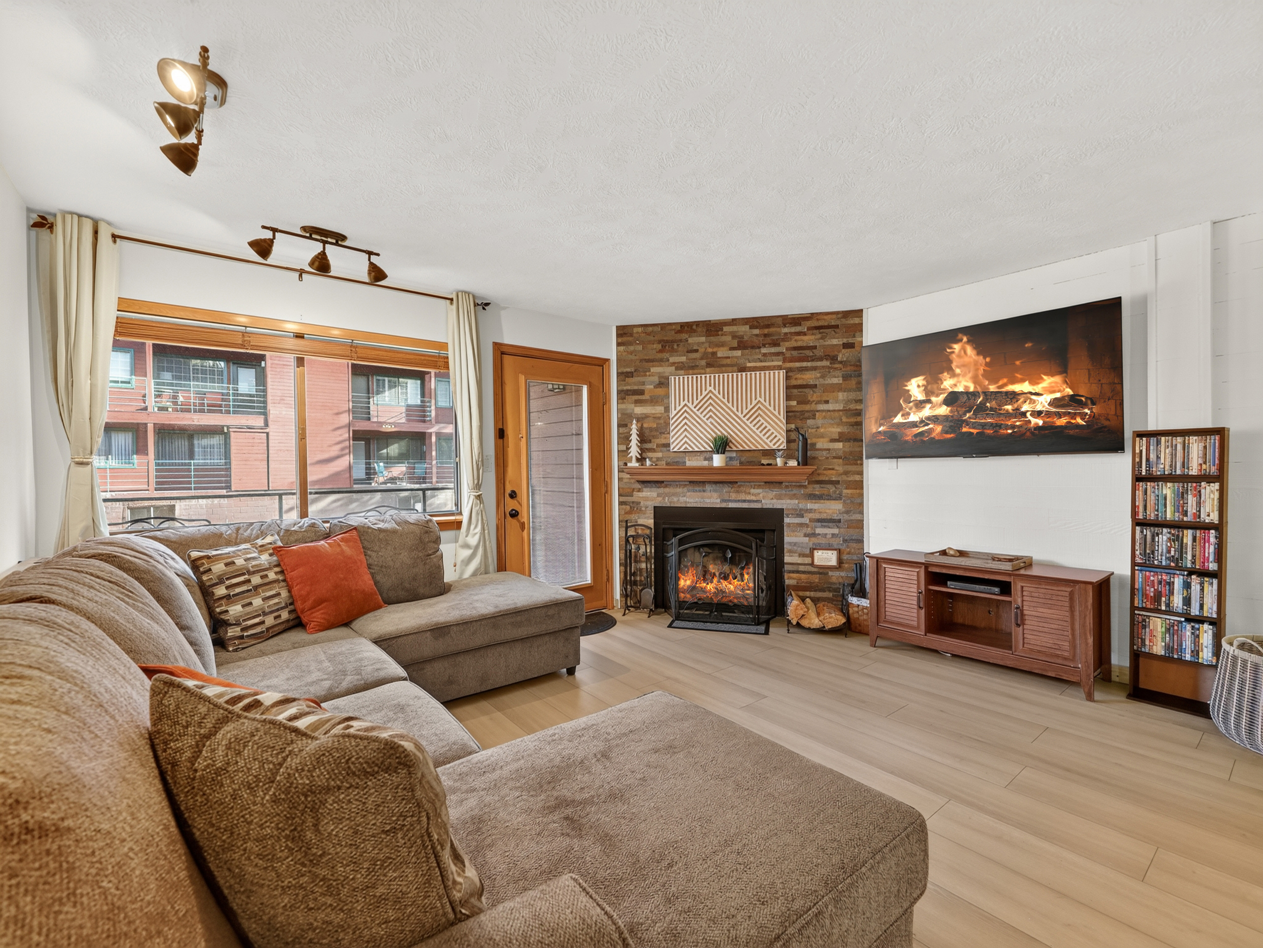Settle into this inviting living room where a stone fireplace and plush sectional create your perfect mountain retreat. Large windows frame the surrounding area, while cozy evenings await by the warm glow of the fire.