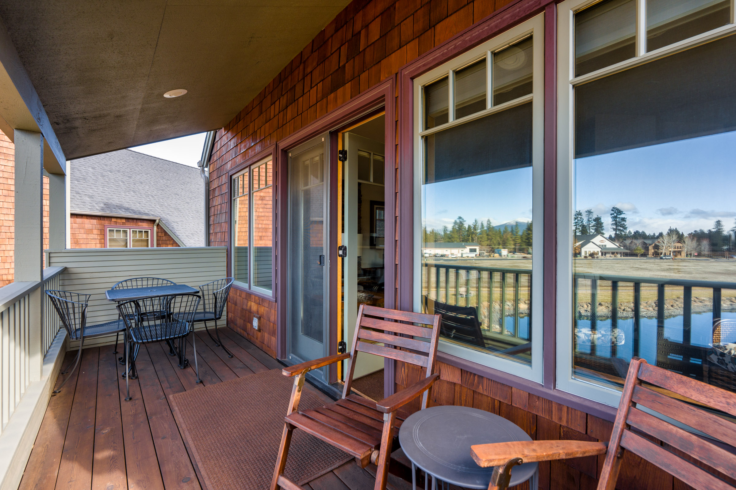 Relax on your private waterfront balcony with comfortable seating and stunning lake views stretching to distant mountains.