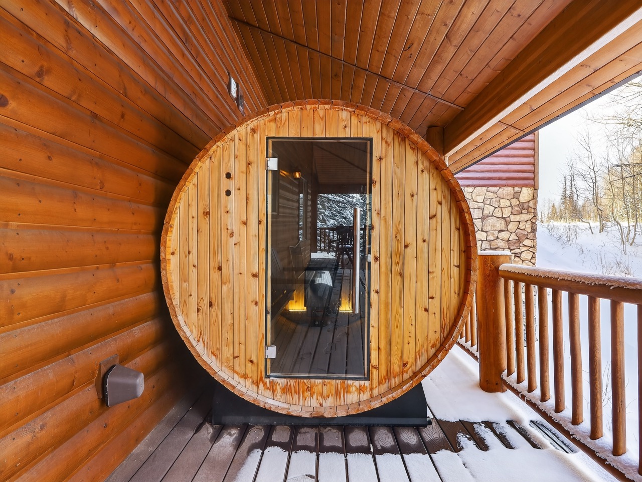 Step into your private barrel sauna, where warm cedar walls embrace you in soothing heat while winter's beauty unfolds beyond.