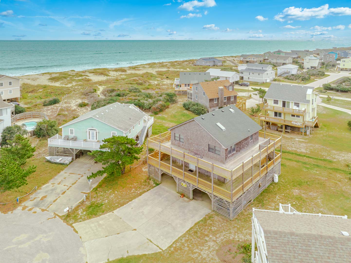 Coastal beach community with vacation homes nestled between ocean and dunes, offering seaside charm and natural surroundings.