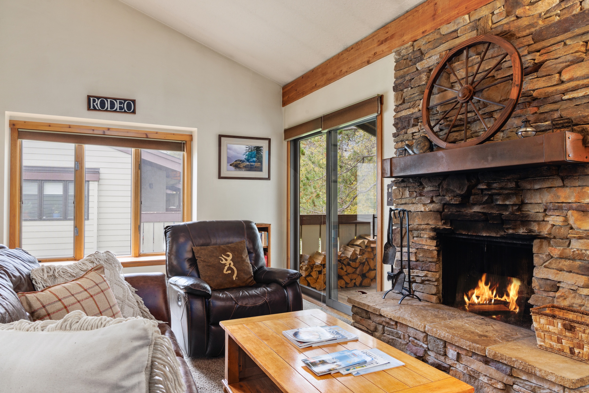 Settle into your own rustic retreat where crackling flames warm the room and natural light pours through large windows. The cozy leather recliner and stone fireplace create the perfect spot to unwind after exploring.