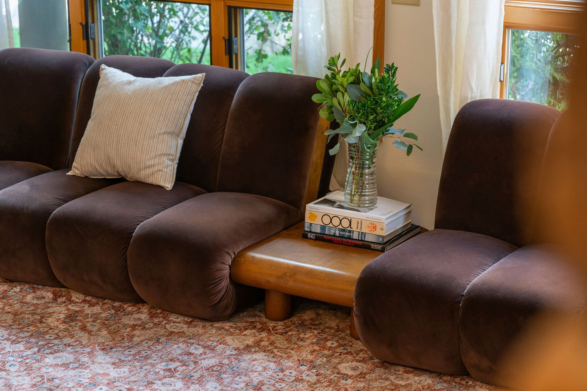 Sink into plush cushions where natural light and garden views create your perfect retreat. Fresh greenery and thoughtful design make this your cozy corner to unwind.
