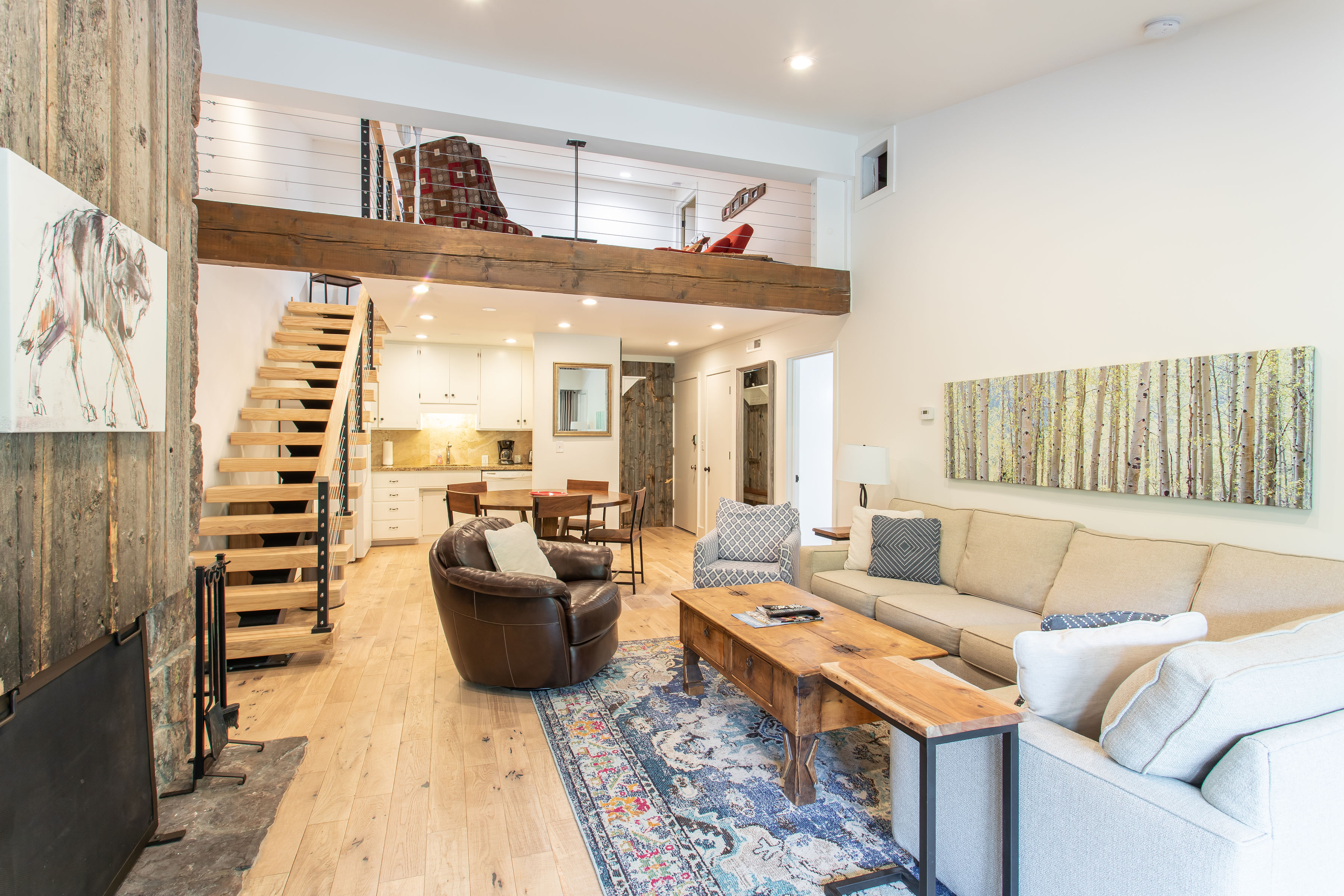 Living area looking to loft space and kitchen