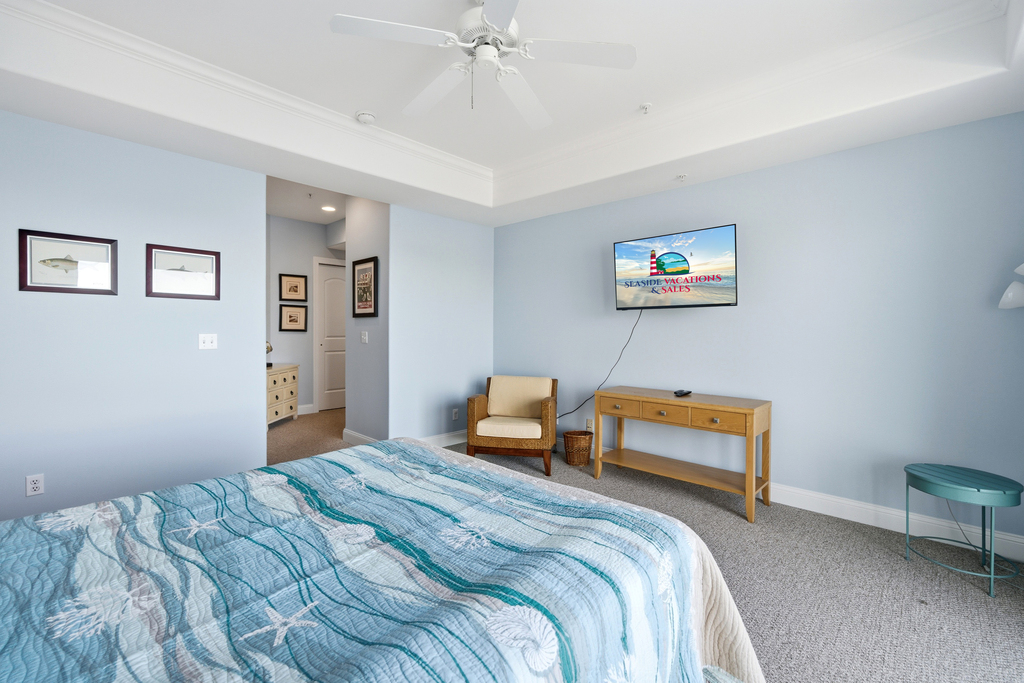 Primary Bedroom has Balcony Access and Flat Screen Smart TV.