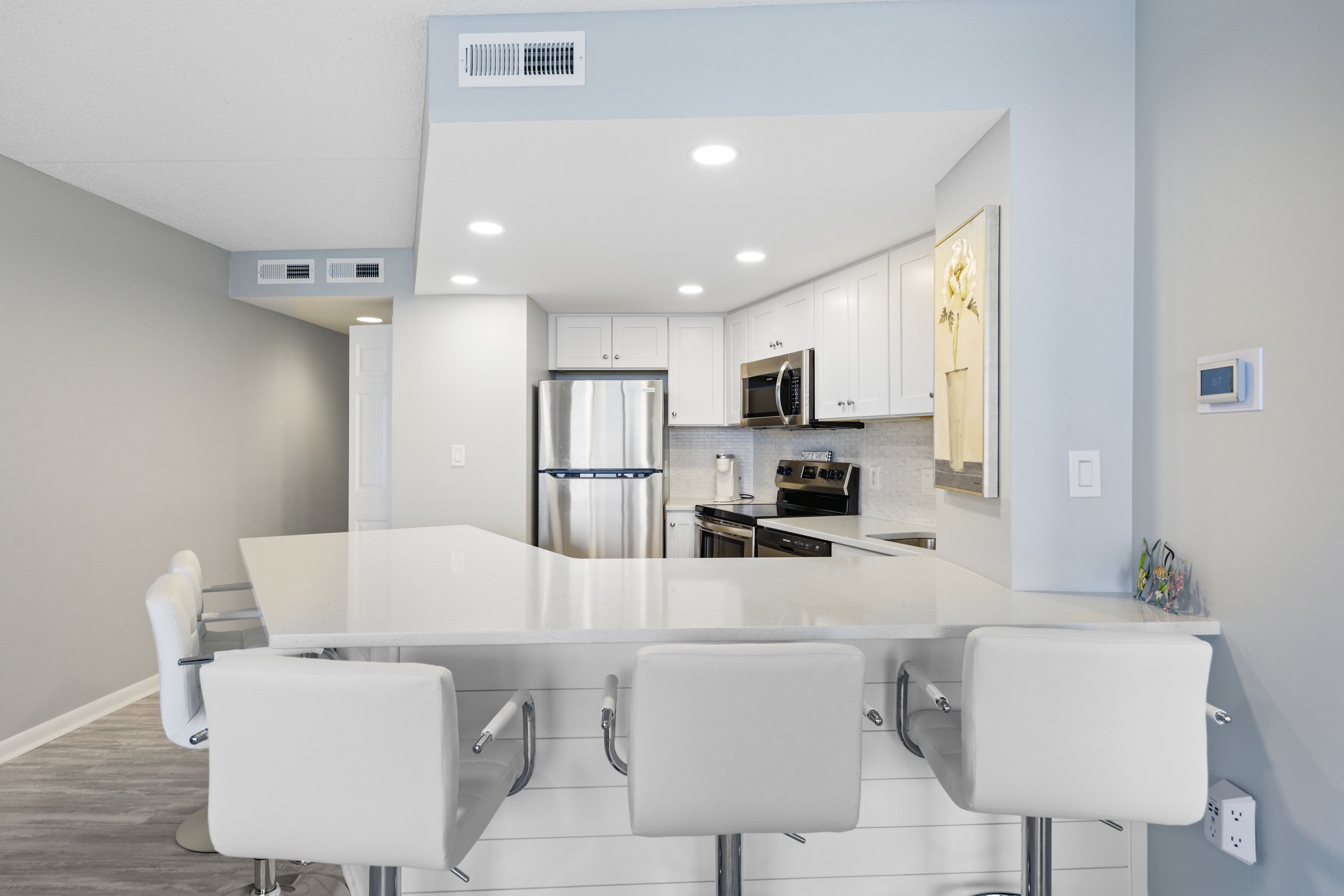 The bright white kitchen is modern and clean.