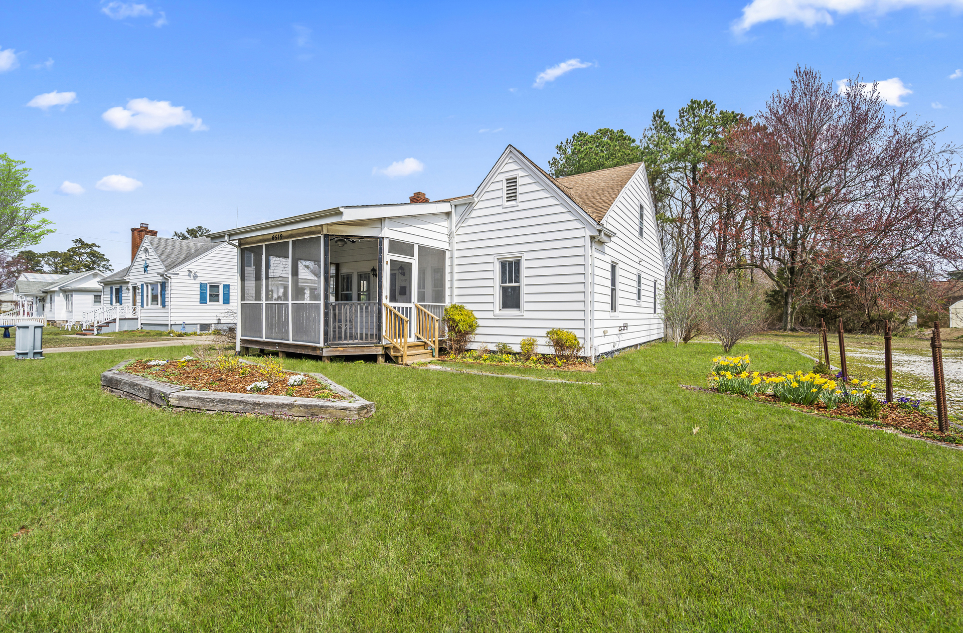 Lovely Front Yard and welcoming Screened Porch.