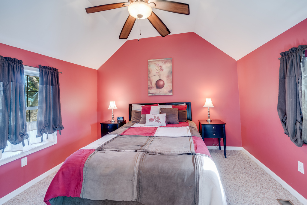 Bedroom 1 is on the 1st Floor with a comfy Queen Bed and warm, rosy walls.