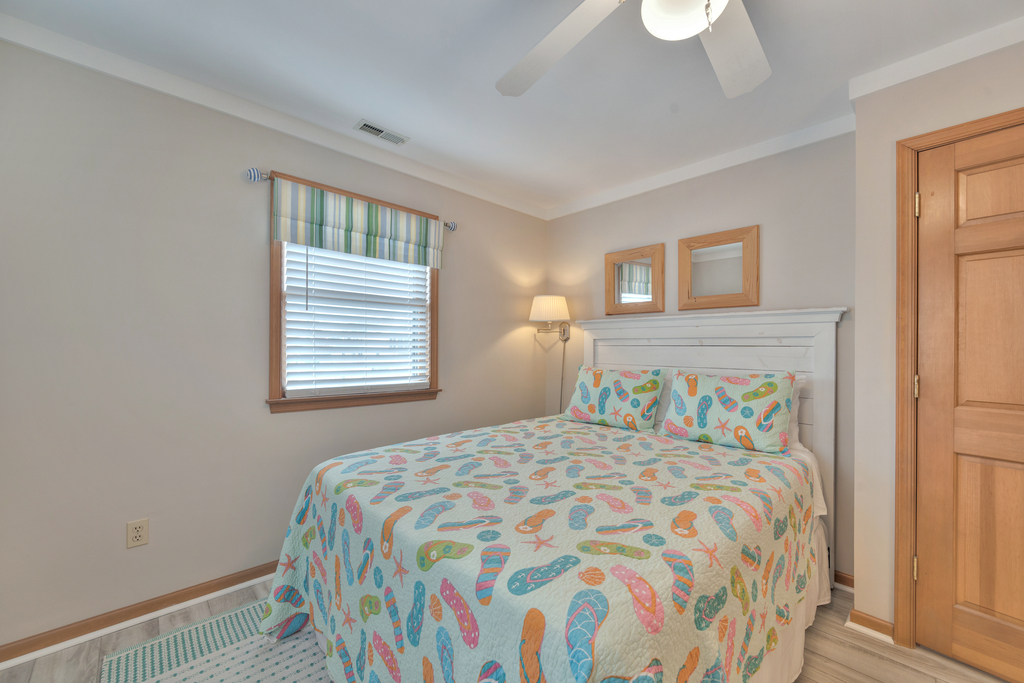 Bedroom 2 also has a Queen Bed and sunny yellow walls.