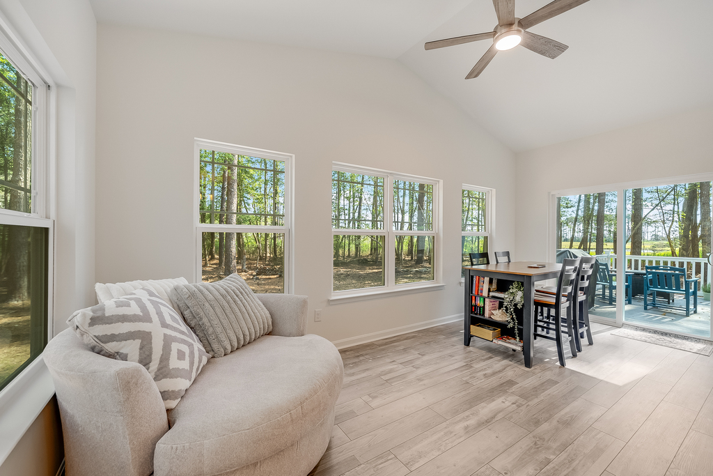The Sunroom lines the back of the house with a Dining Area and comfy seating.