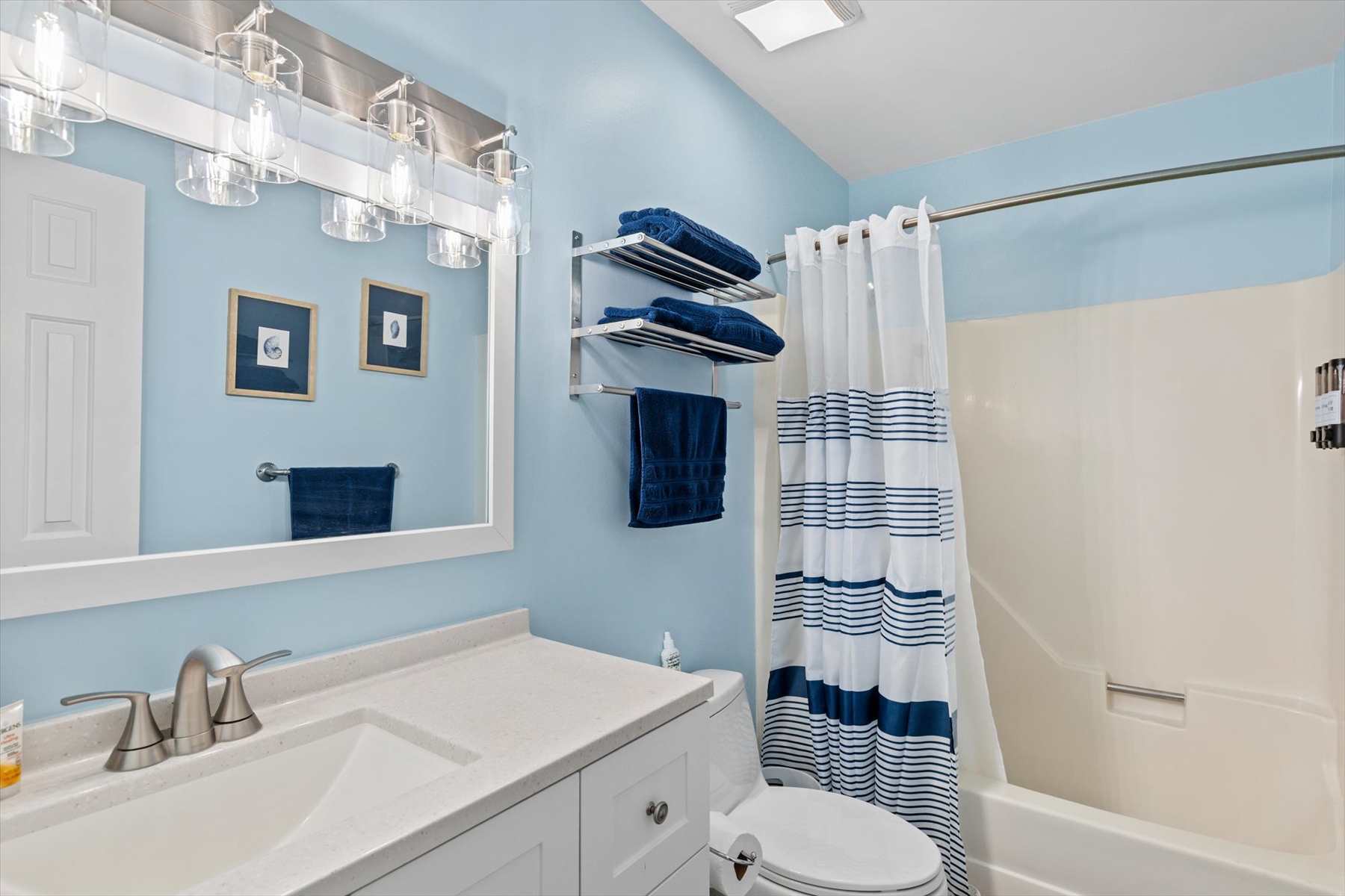Refresh in style with a clean, well-lit bathroom space complete with handy wall shelves for your towels.