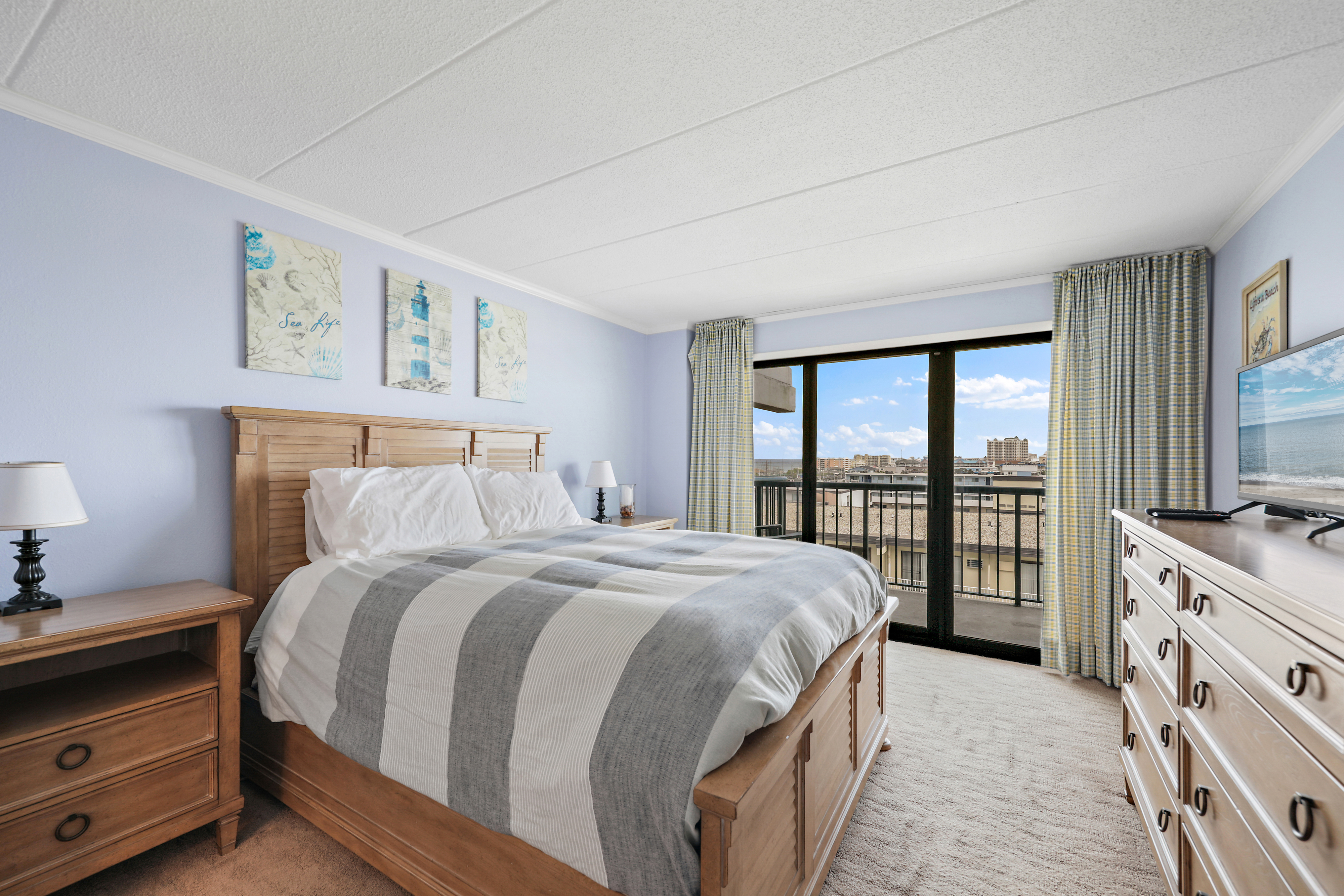 The Primary Bedroom has a plush Queen Bed and private balcony access!