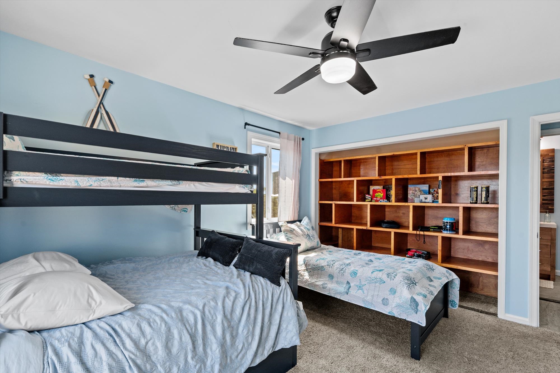 This bedroom angle showcases a massive, beautiful built-in wooden bookshelf, offering incredible storage space for your vacation essentials.