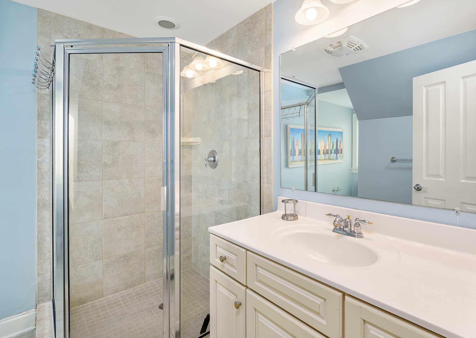 The attached bathroom has a large corner shower and plenty of counter space