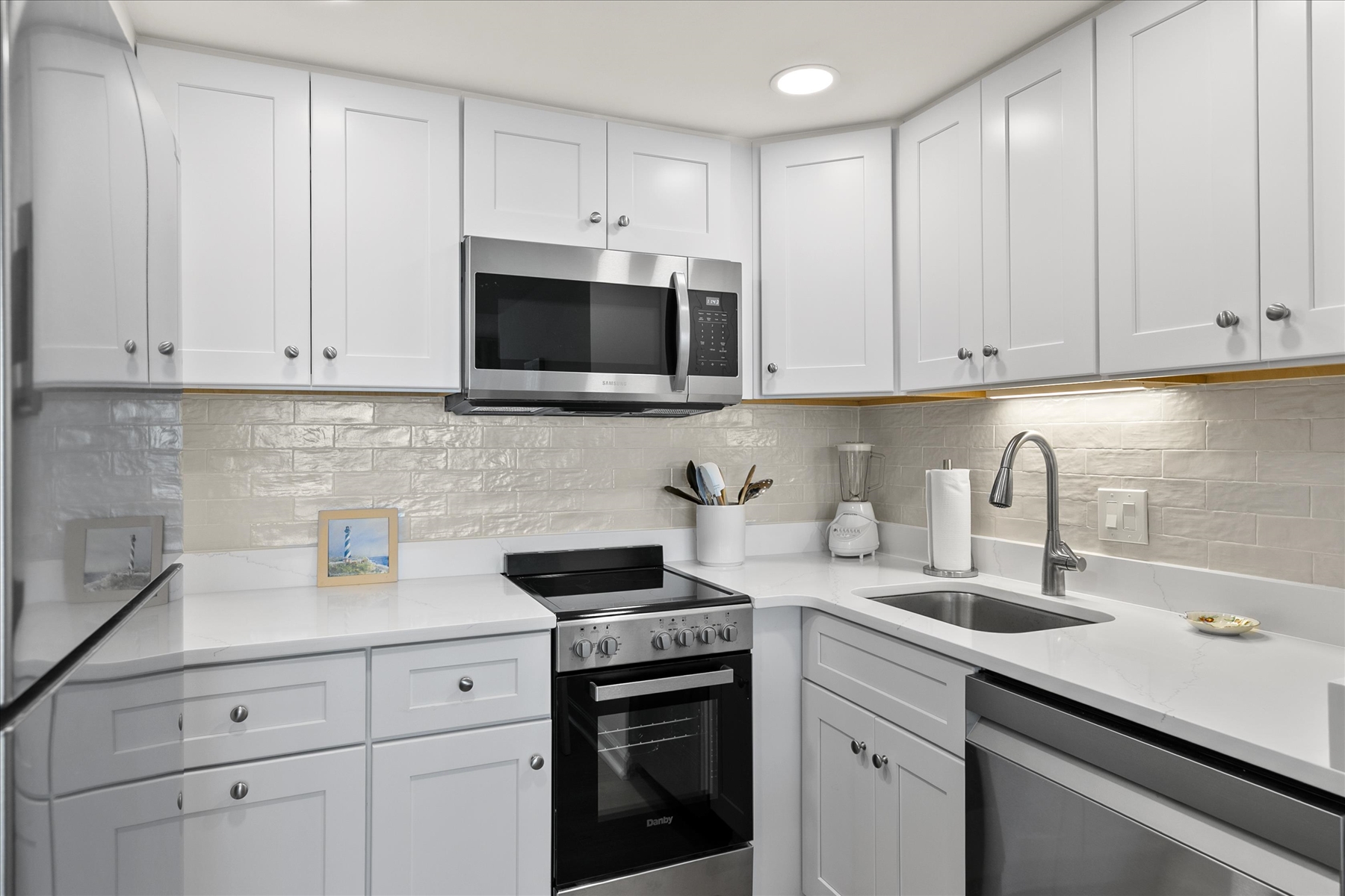 Cook with ease in a bright, modern cooking space featuring a stylish tile backsplash.