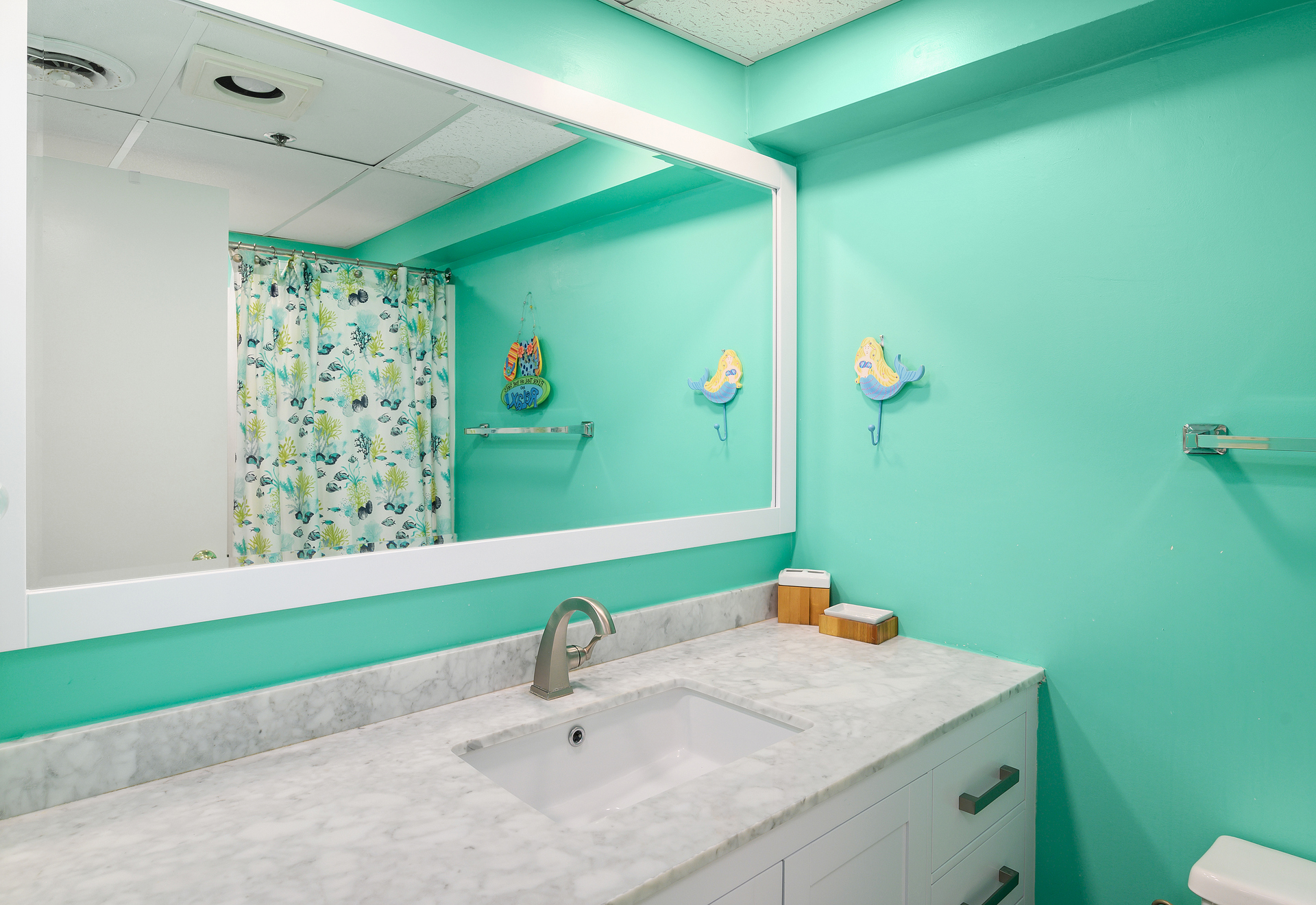 The 2nd Bath has been tastefully decorated with a beautiful vanity and a bright sea-foam Green