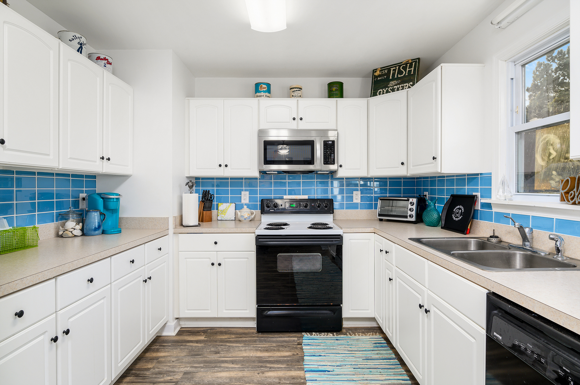 Just love the Beachy Blue Backsplash and bright White Cabinetry.