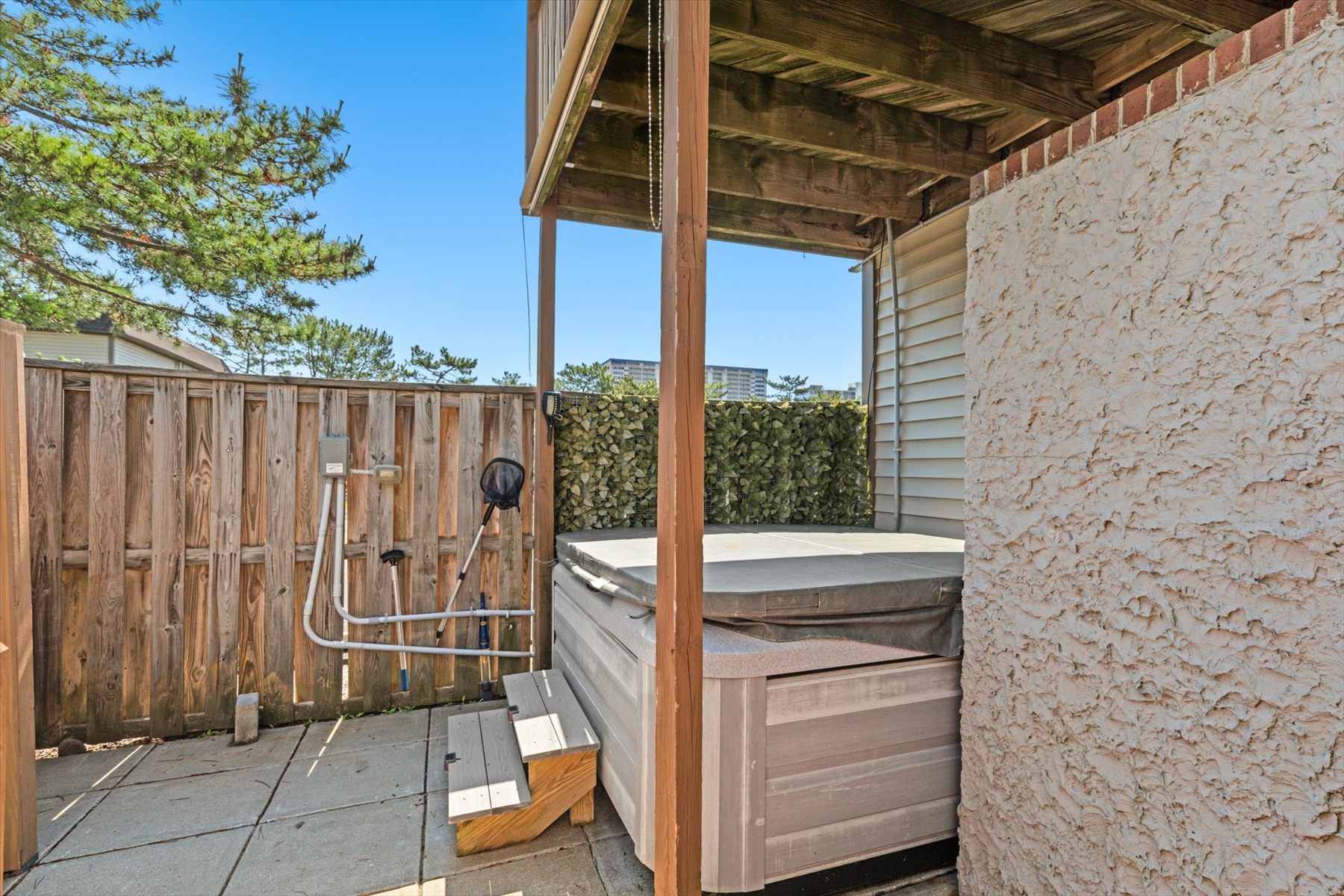 This inviting lower patio setup features plenty of room to unwind outdoors, complete with a private hot tub station.