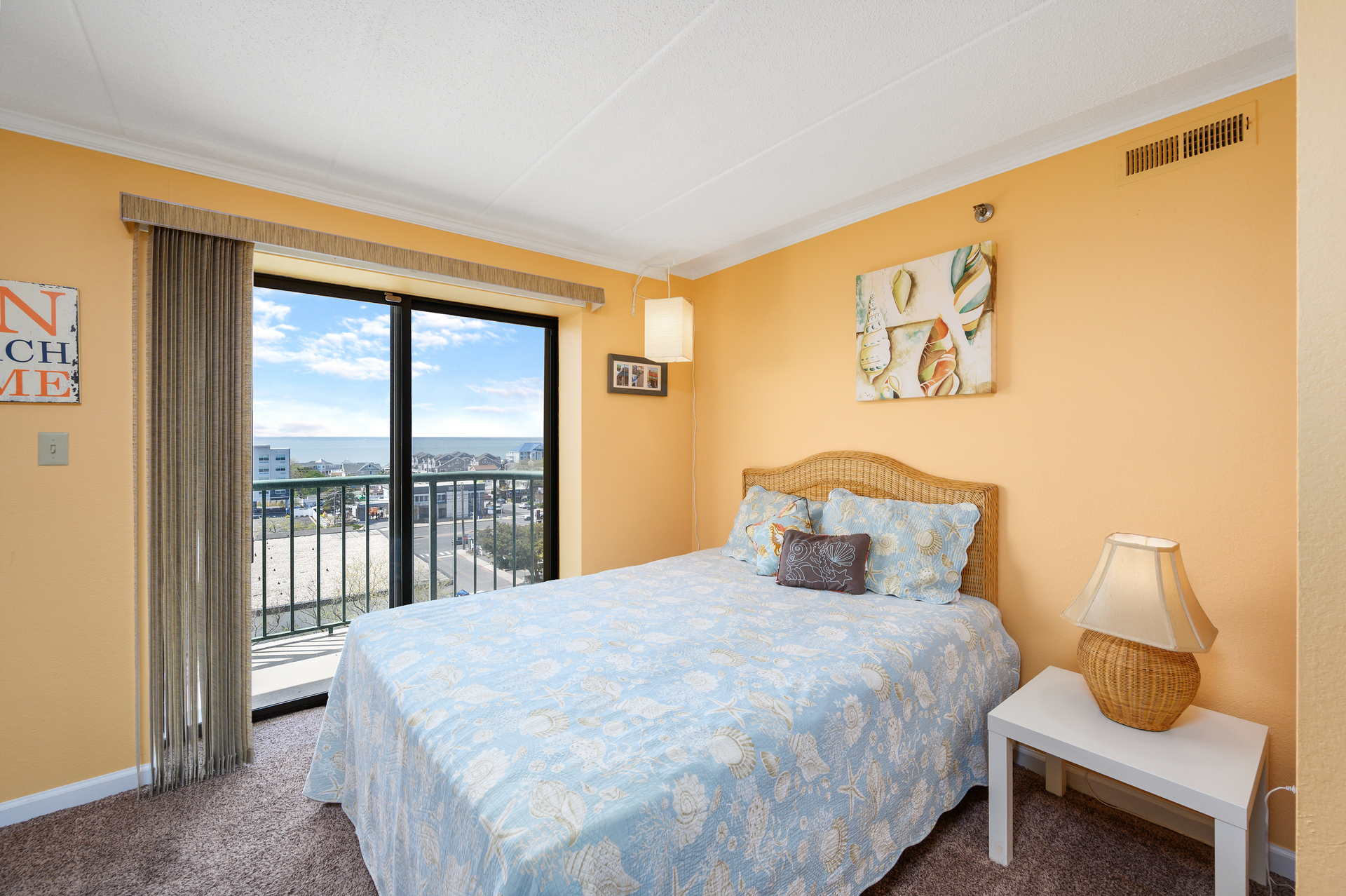 Bedroom 2 sleeps 2 guests with a plush Queen bed and warm, summer tones