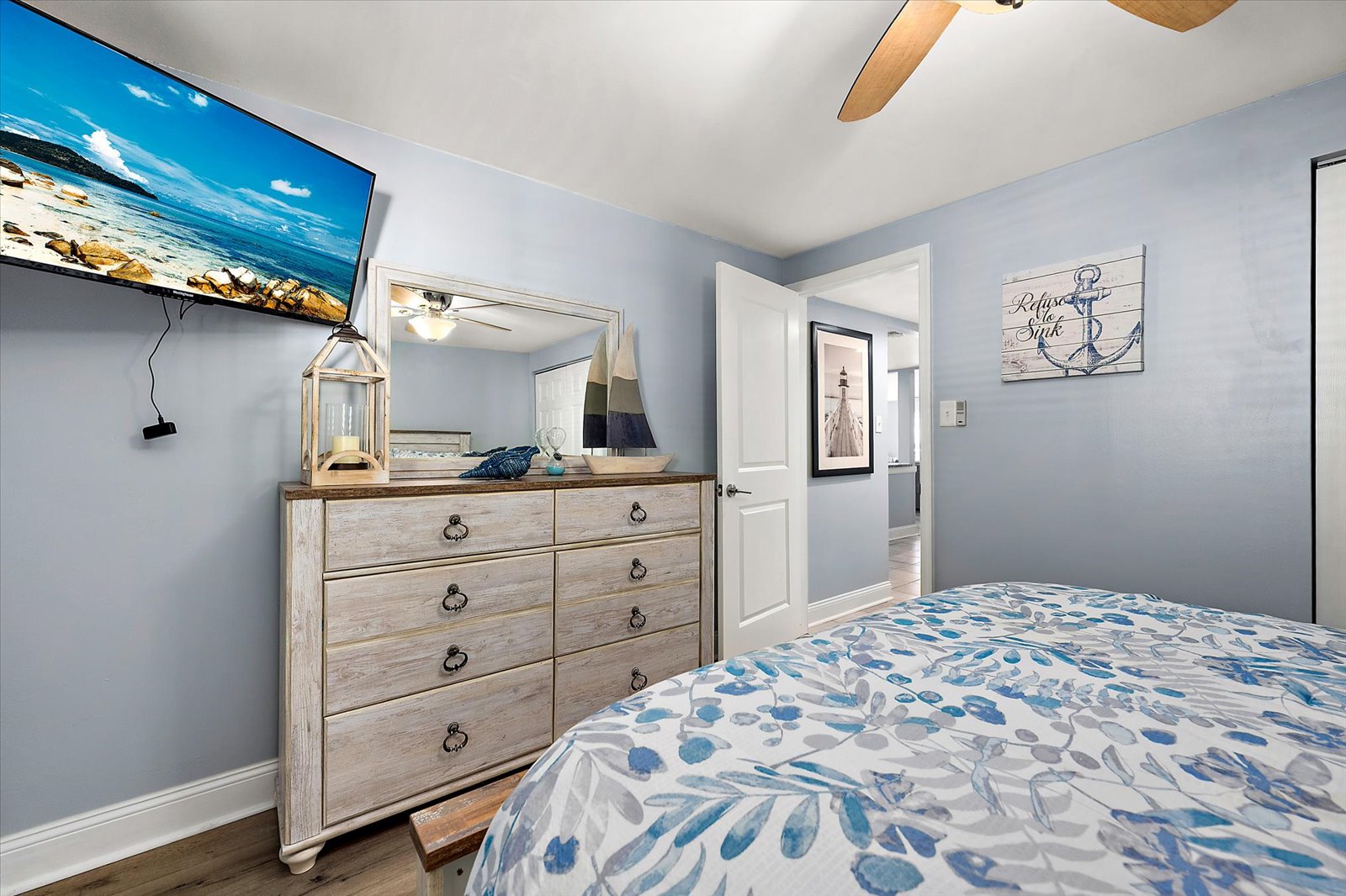 This bright room offers a thoughtful layout with easy access to the hallway and matching coastal decor.
