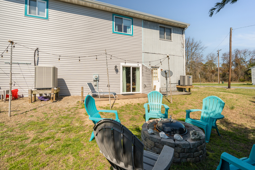 Spacious Backyard with Adirondacks, a Fire Pit, and a Charcoal Grill.