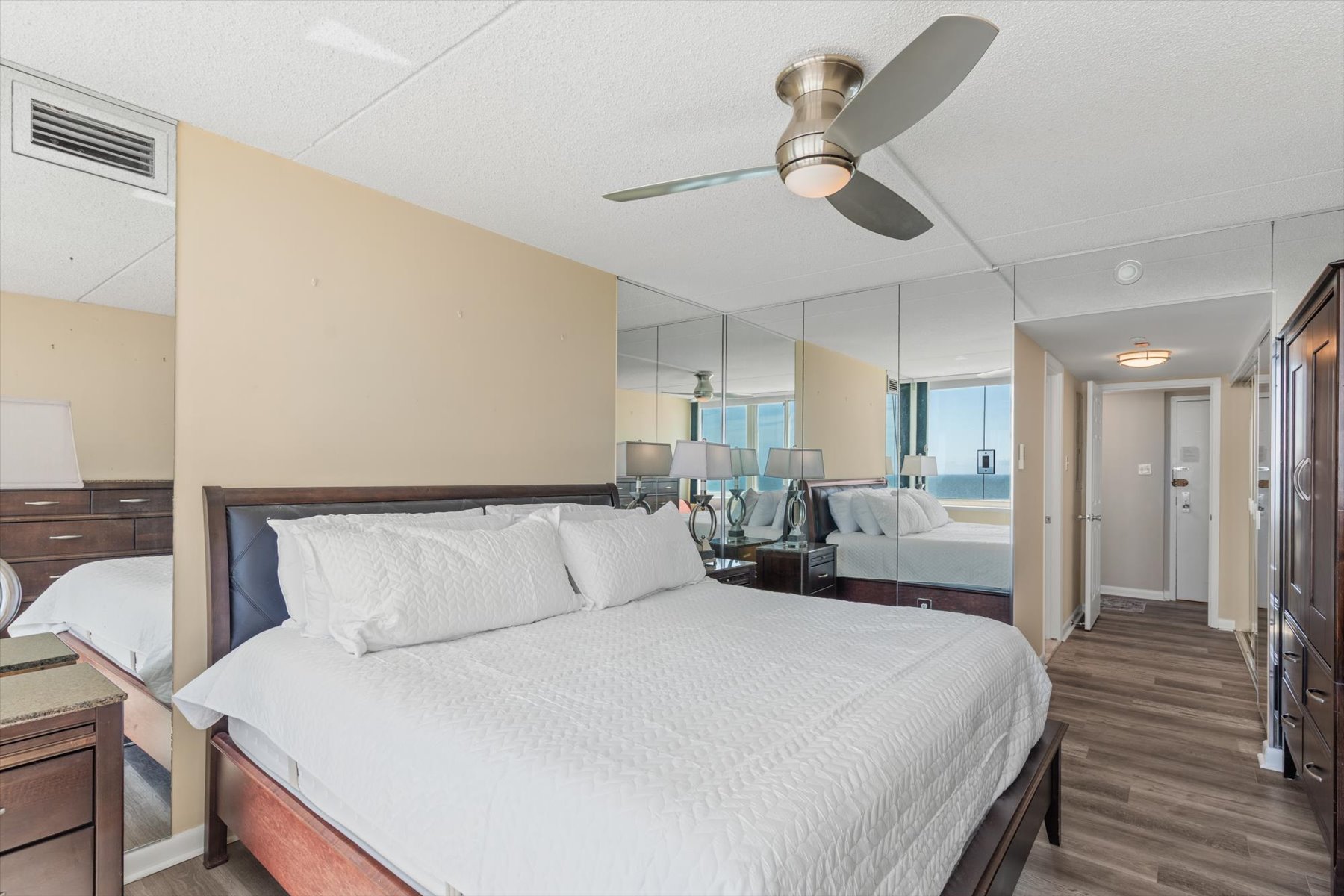 Rest easy in this comfortable bedroom space, complete with a cooling ceiling fan and cozy plush bedding.